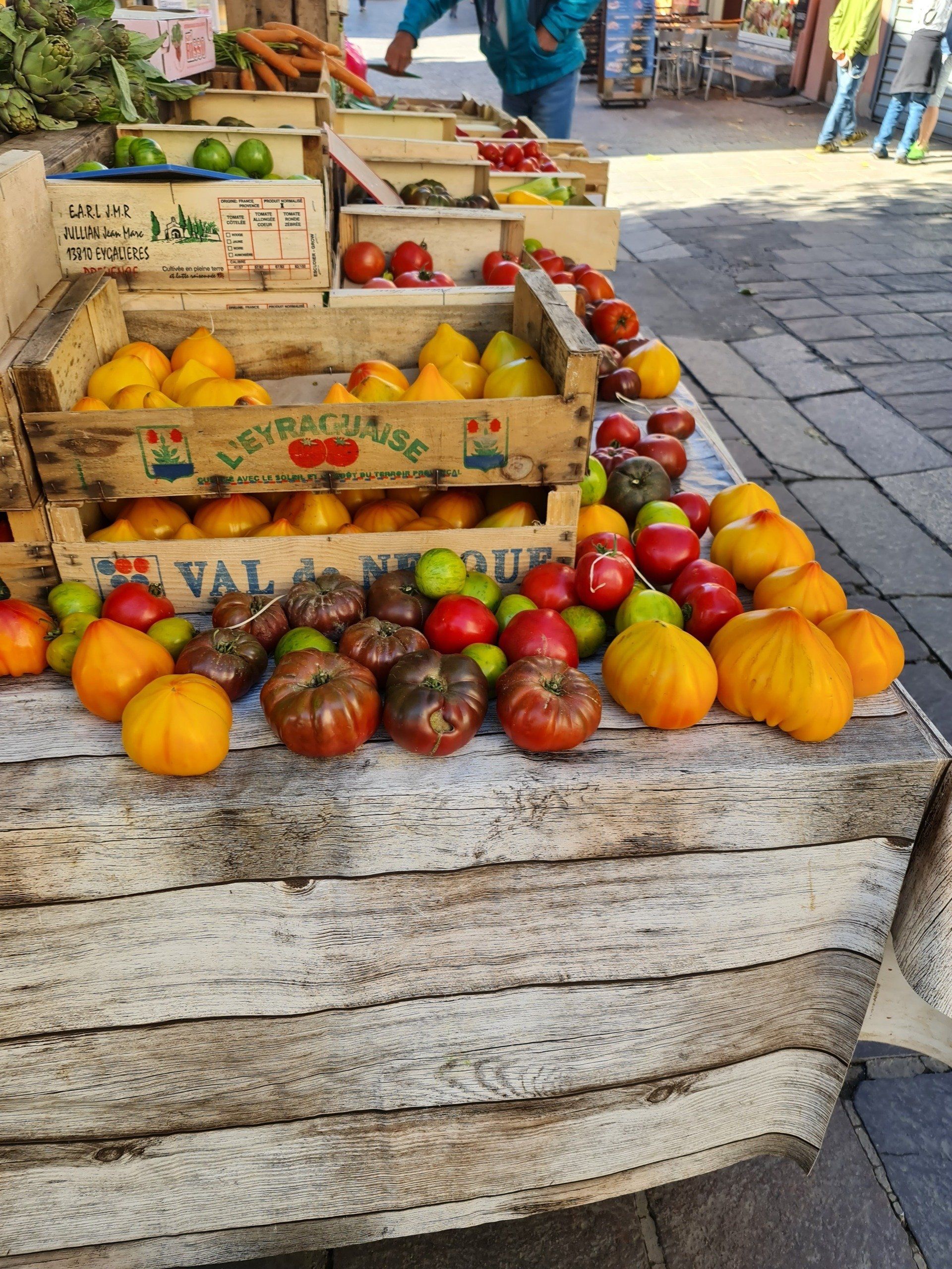 Marktstand in grau auf dem Markt Le Grau du Roi, Gemüse, Möhren Paprika und bunte verschiedengroße Tomaten werden angeboten