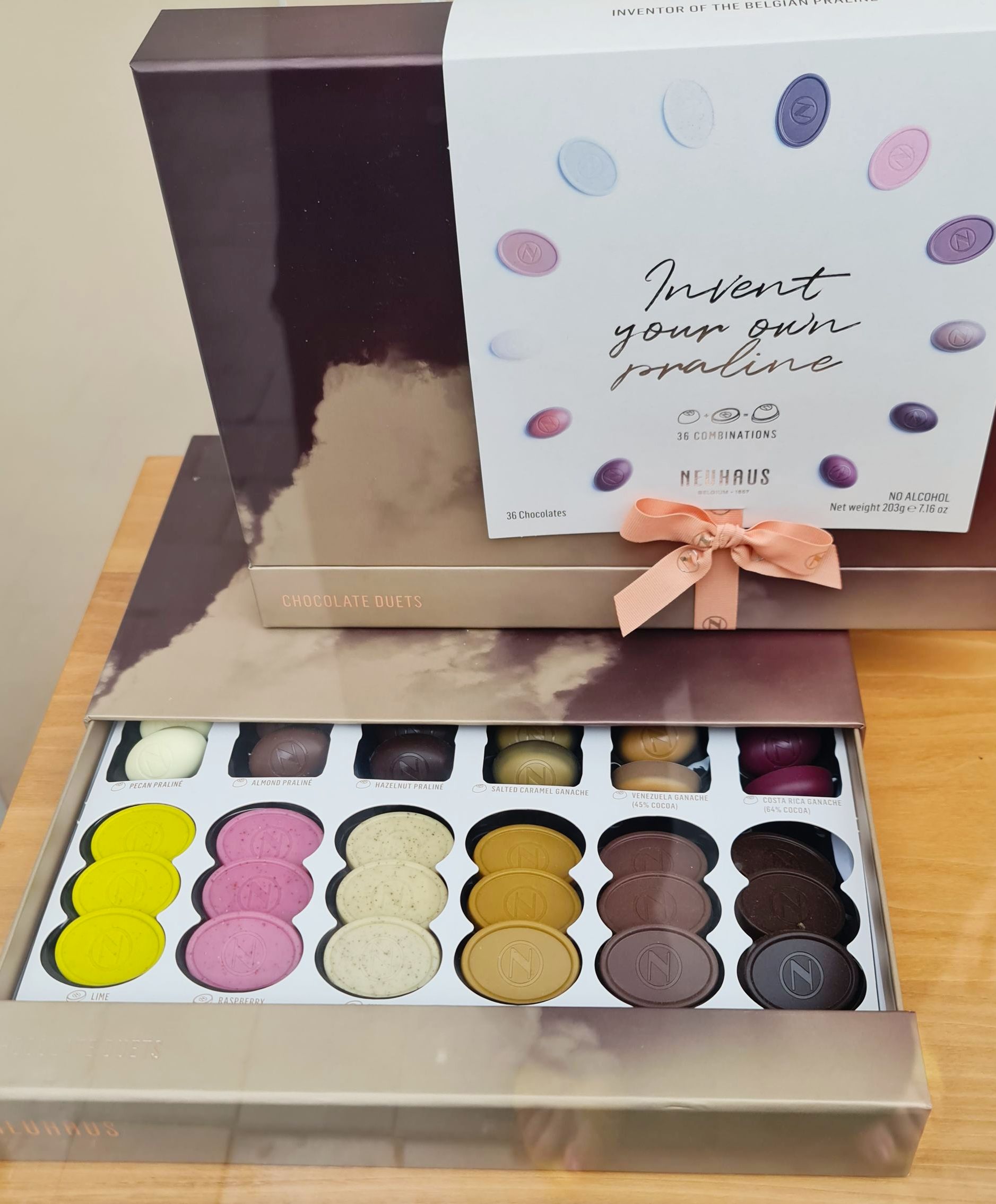 Pralinen in verschiedenen Farben in Form von runden Plätzchen eine Reihe immer gleiche Farbe aus belgischer Schokolade in einer Geschenkschachtel