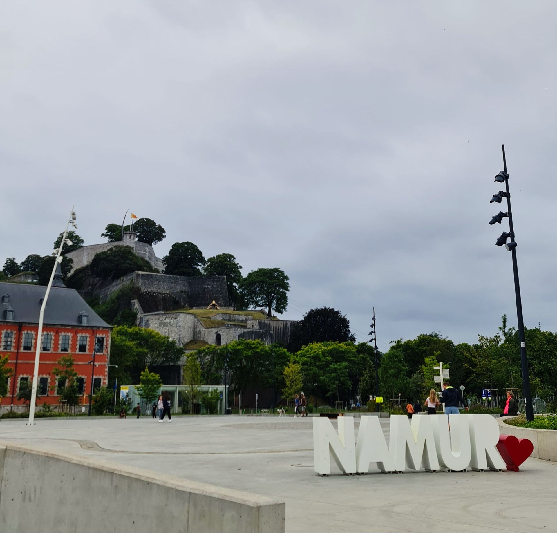 Schriftzug Namur unten auf dem Boden in weißen Großbuchstaben - oben auf dem Berg die Festung