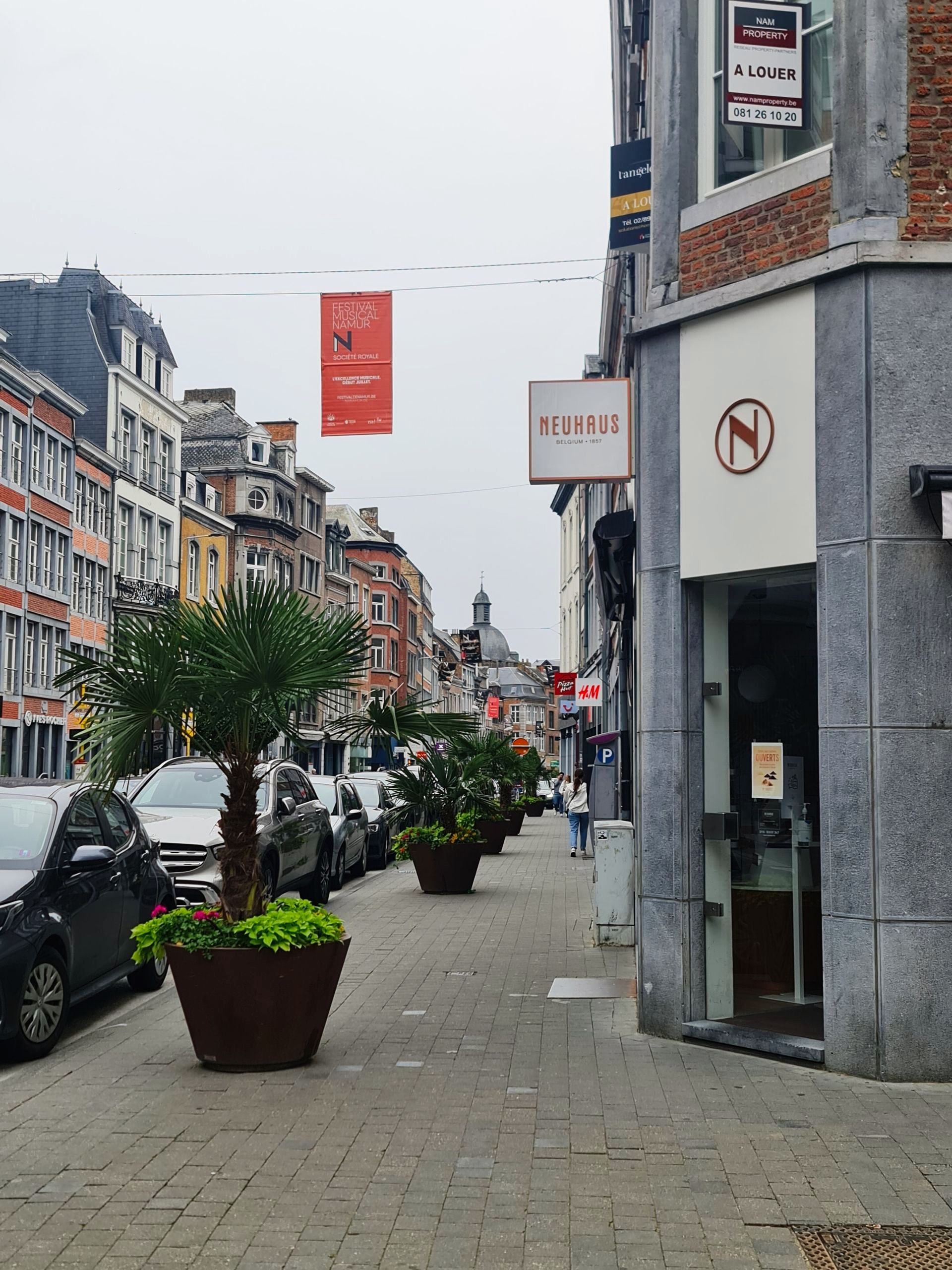 Häuser der Altstadt rechts und lins der Straße- über der Straße eine rote Flagge