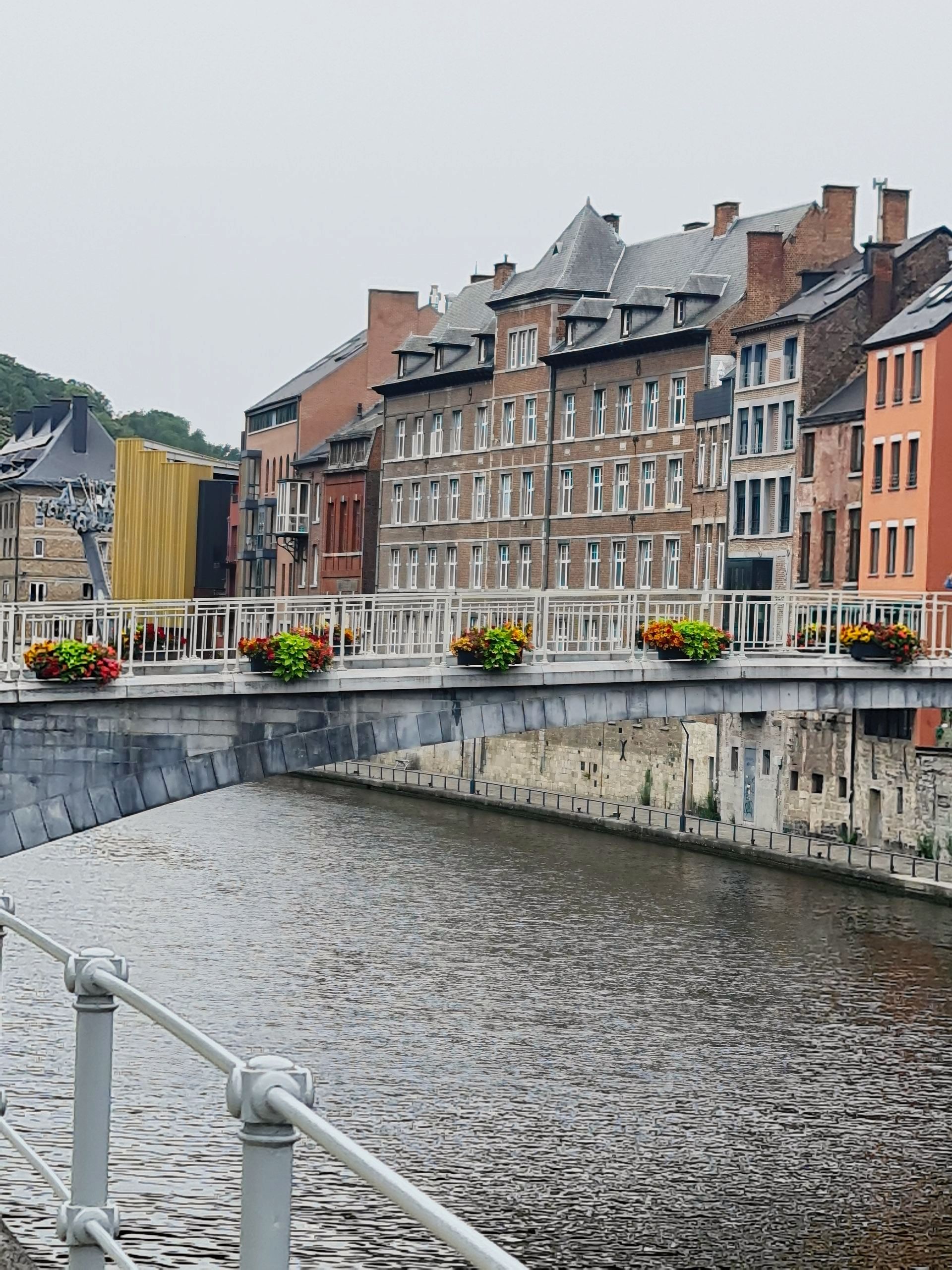 kleine Brücke über einen Fluß, am Geländer schöne Blumen in Kästen