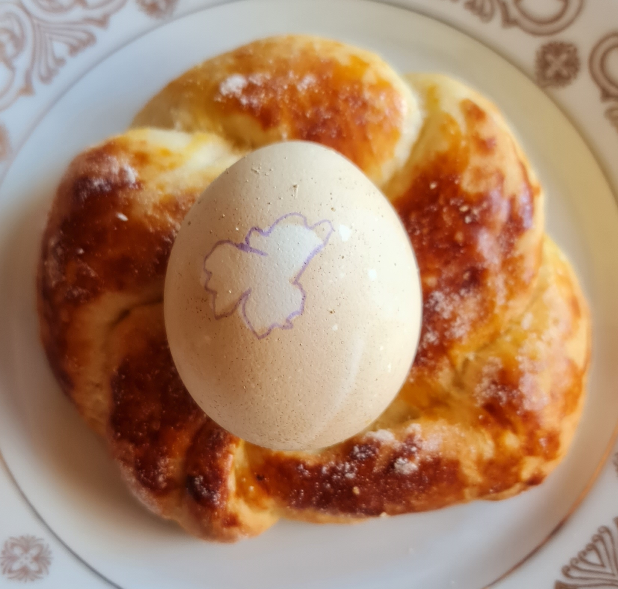 Osterbrot als Kranz in der Mitte ein Osterei
