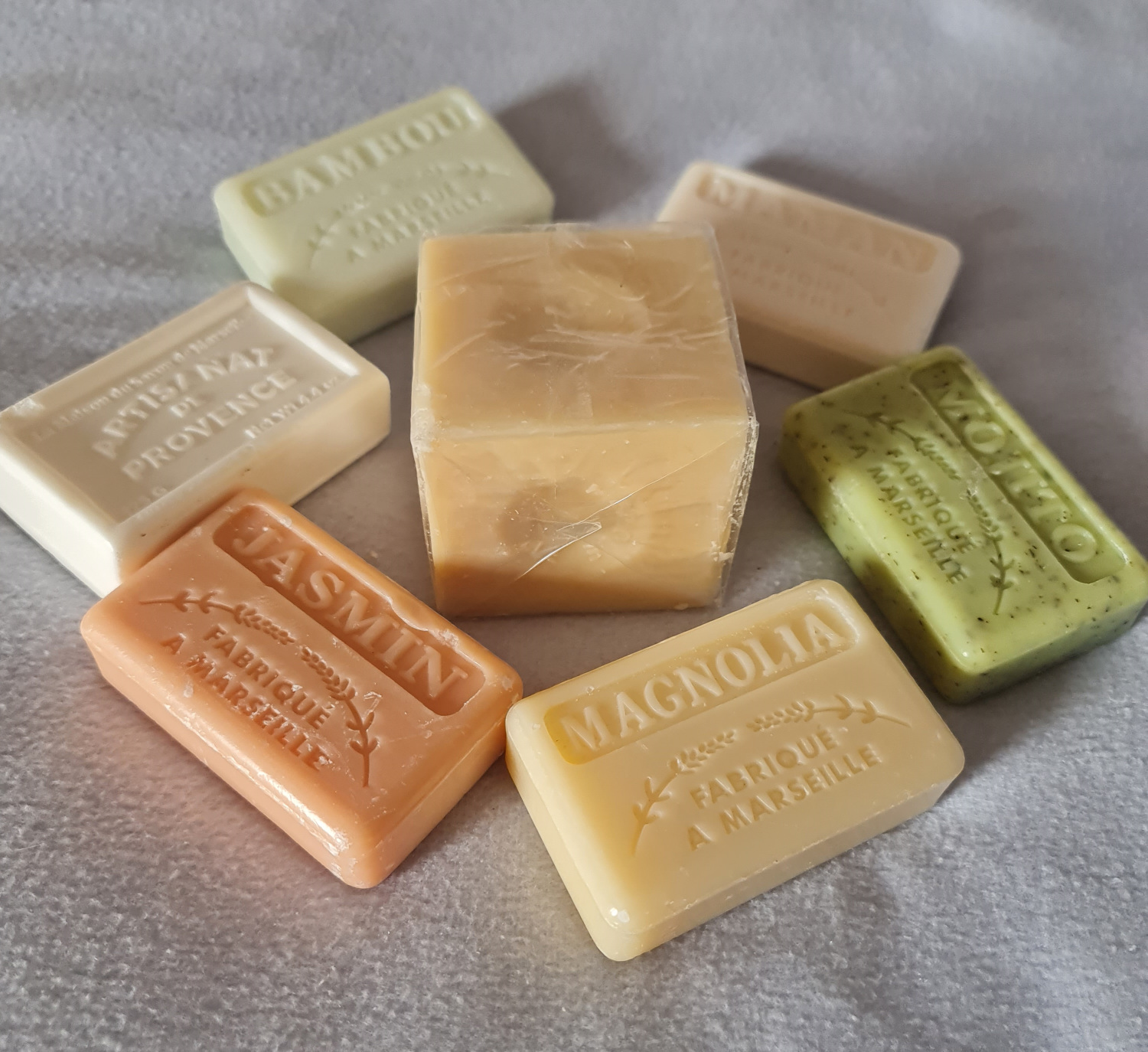 verschiedenfarbige Seifenstücke im Kreis in der Mitte ein weißer Seifenwürfel