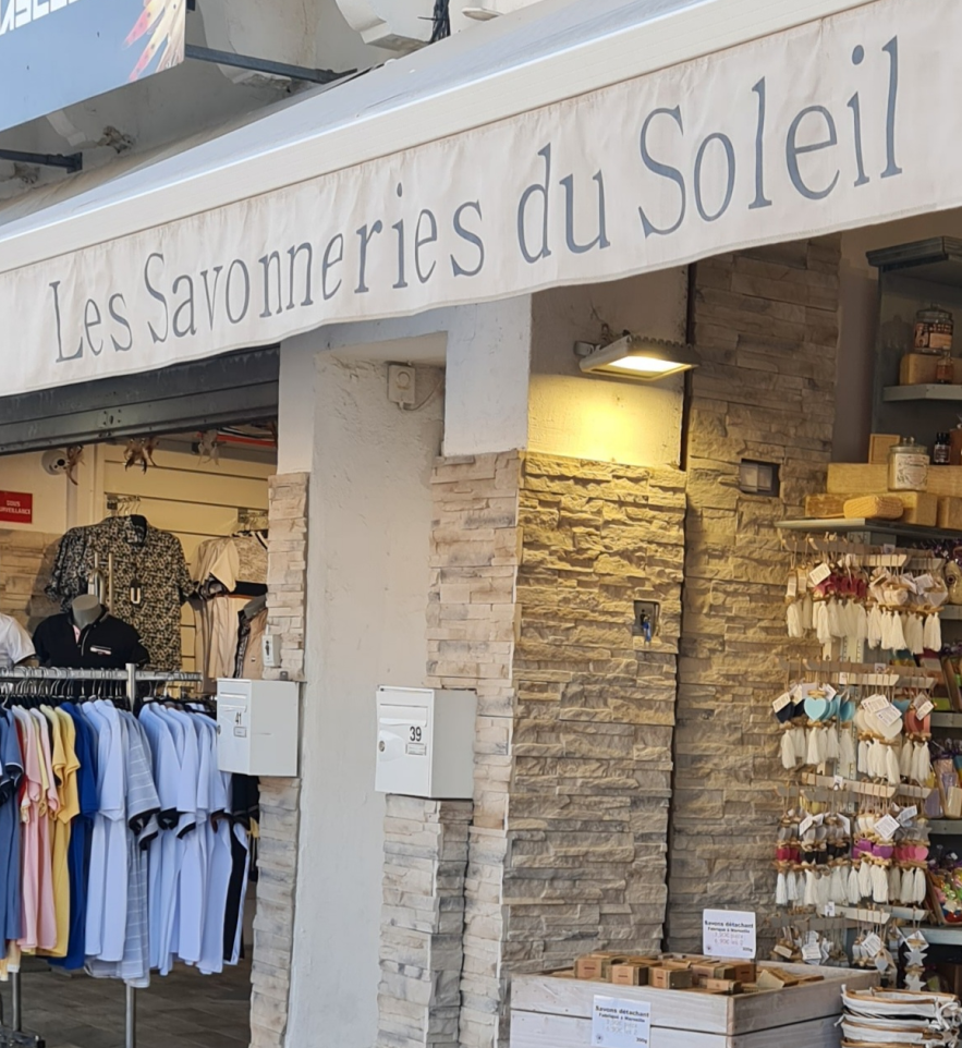 ein Geschäft mit Seifen und einem weißes großen Banner über der Tür , es bezeichnet den Seifenladen