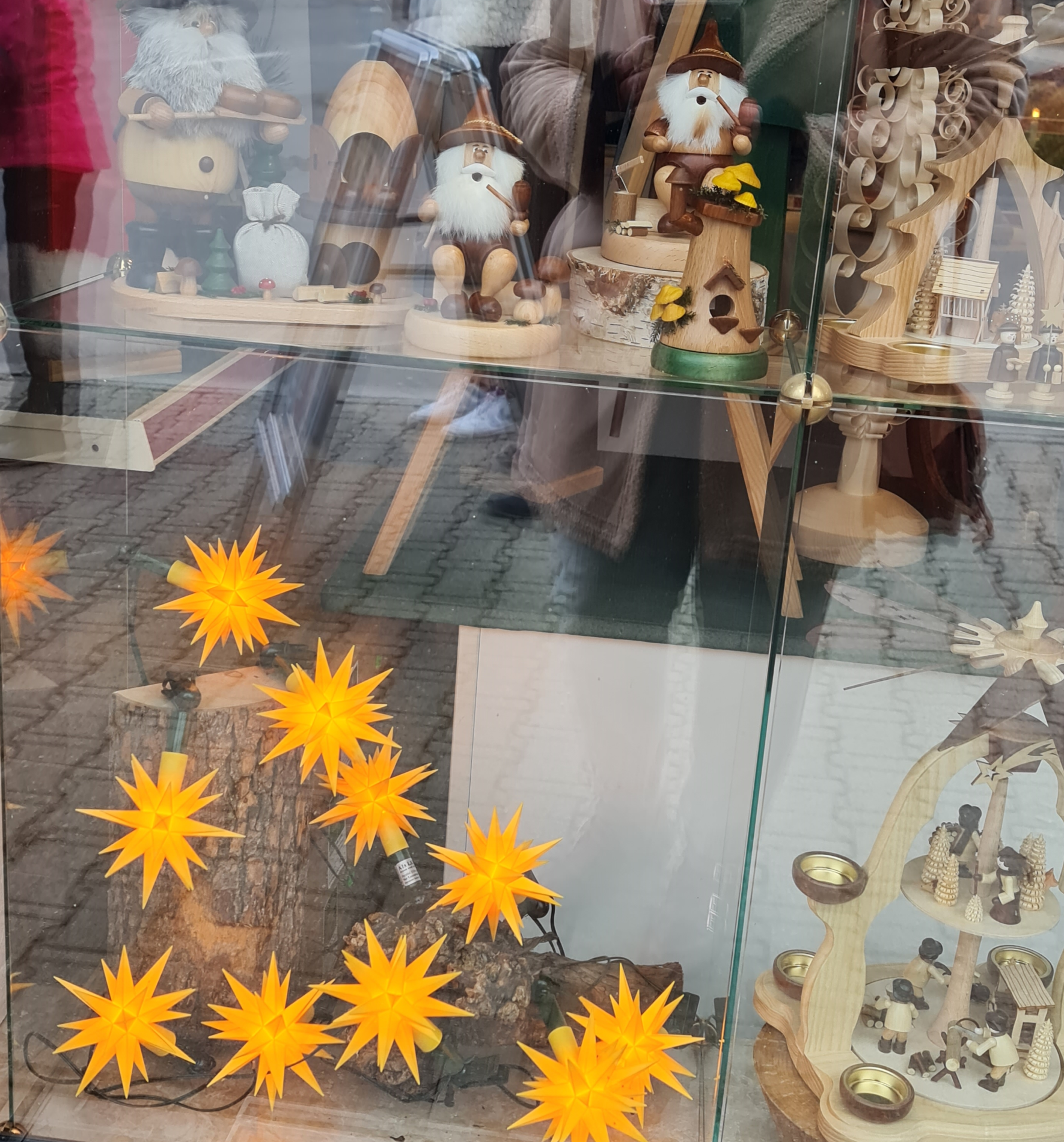 Schaufenster mit kleinen gelben Leuchtsternen und Holzkunst