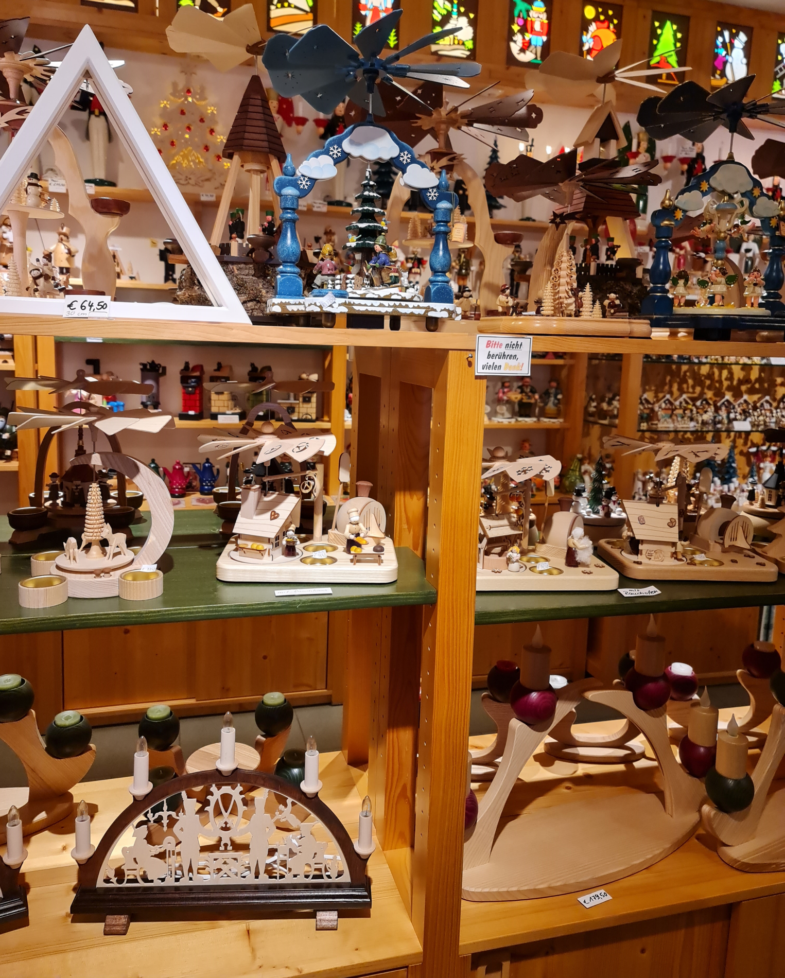 viele Weihnachtsfiguren große und kleine und Pyramiden im Geschäft in Regalen