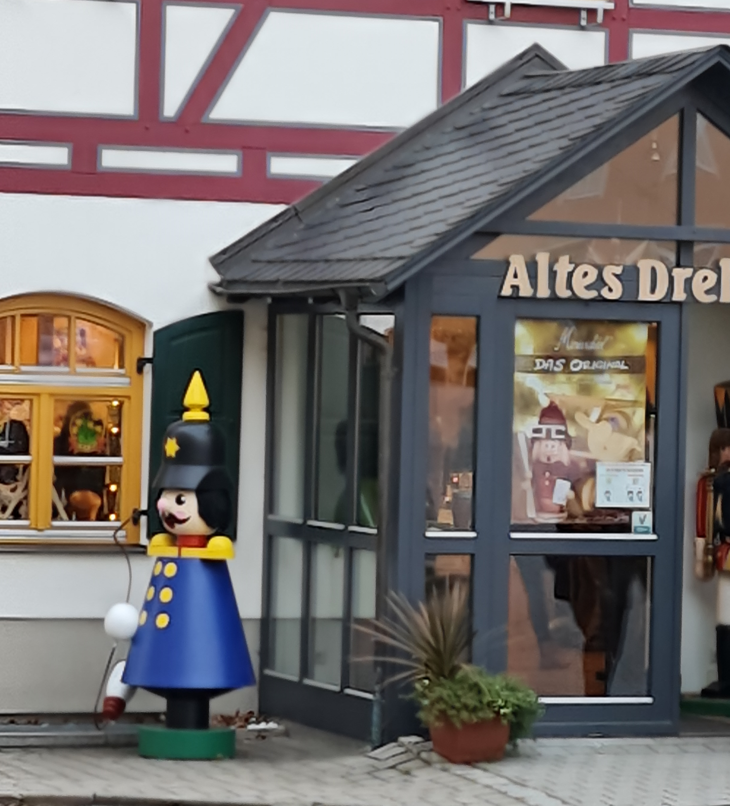 blauer großer Räuchermann vor einem alten Fachwerkhaus in Seiffen Erzgebirge