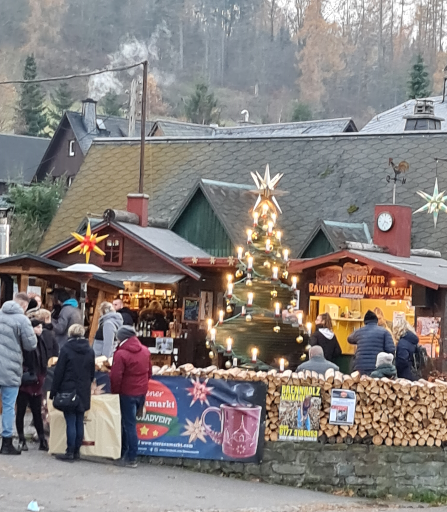kleiner Weihnachtsmarkt mit beleuchtetem Bum und Menschen , Buden mit Essensverkauf