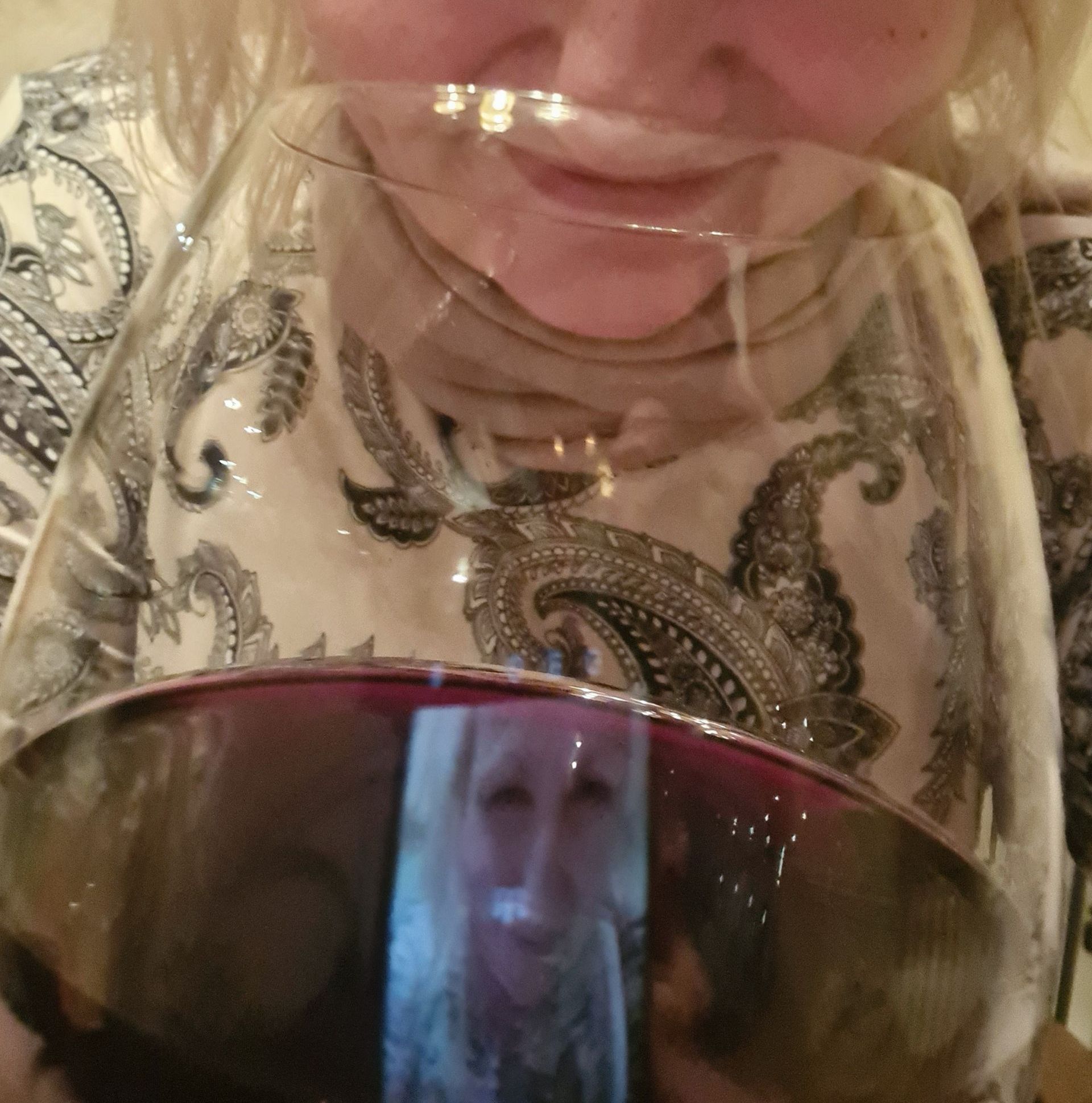 Frau trinkt Rotwein aus einem Glas