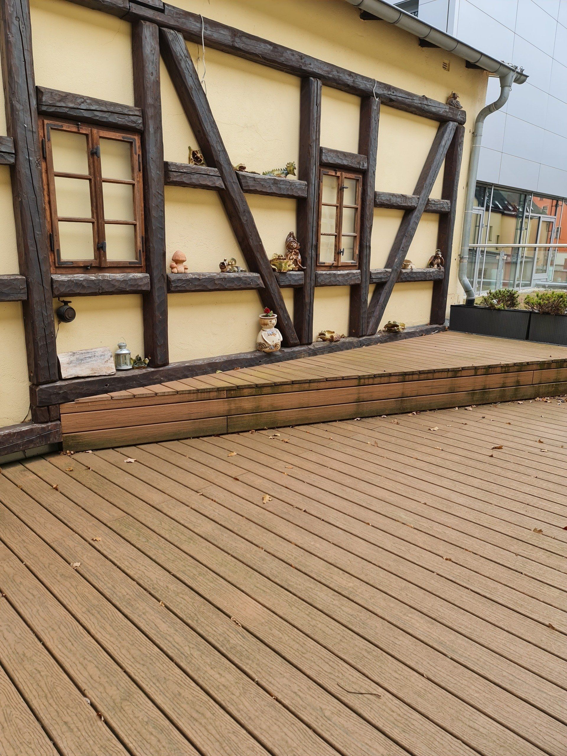 Holzterrasse vor einem Fachwerkhaus mit braunen Balken gehört zum Töpfercafé n Jahnsdorf Erzgebirge