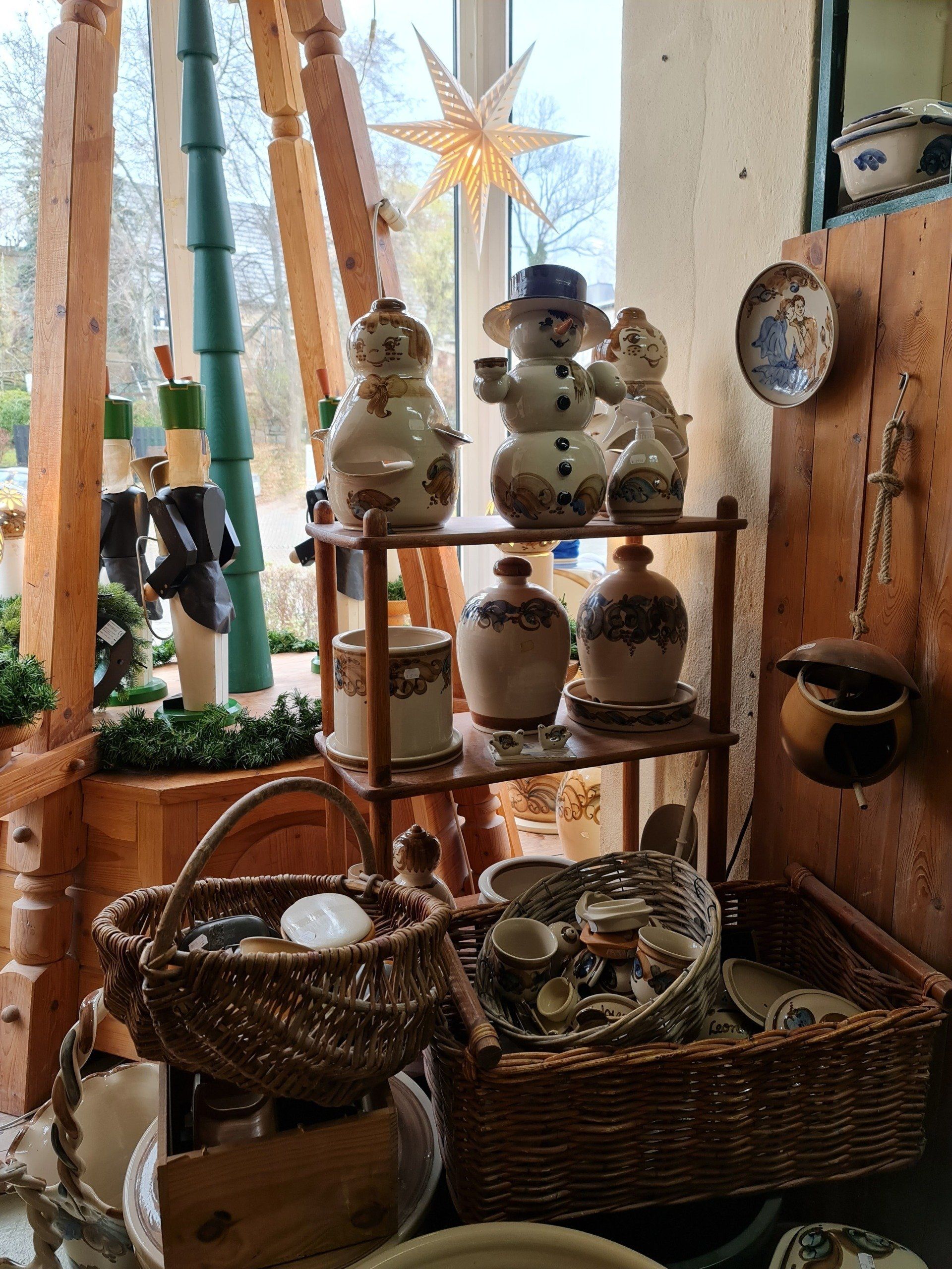 Schneemänner im Fenster dahinter eine Pyramide bei Heyde Keramik im Erzgebirge