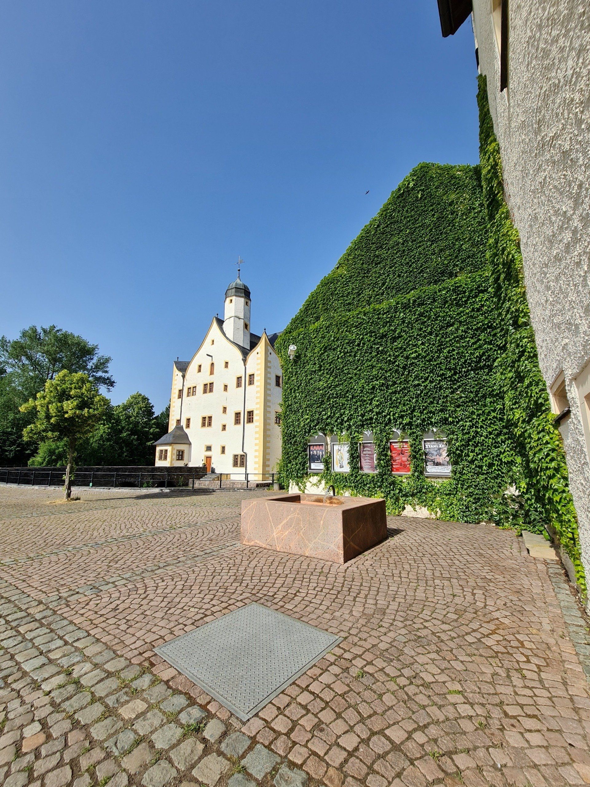 Hof und Schossgebäude mit bewachsenen Mauern