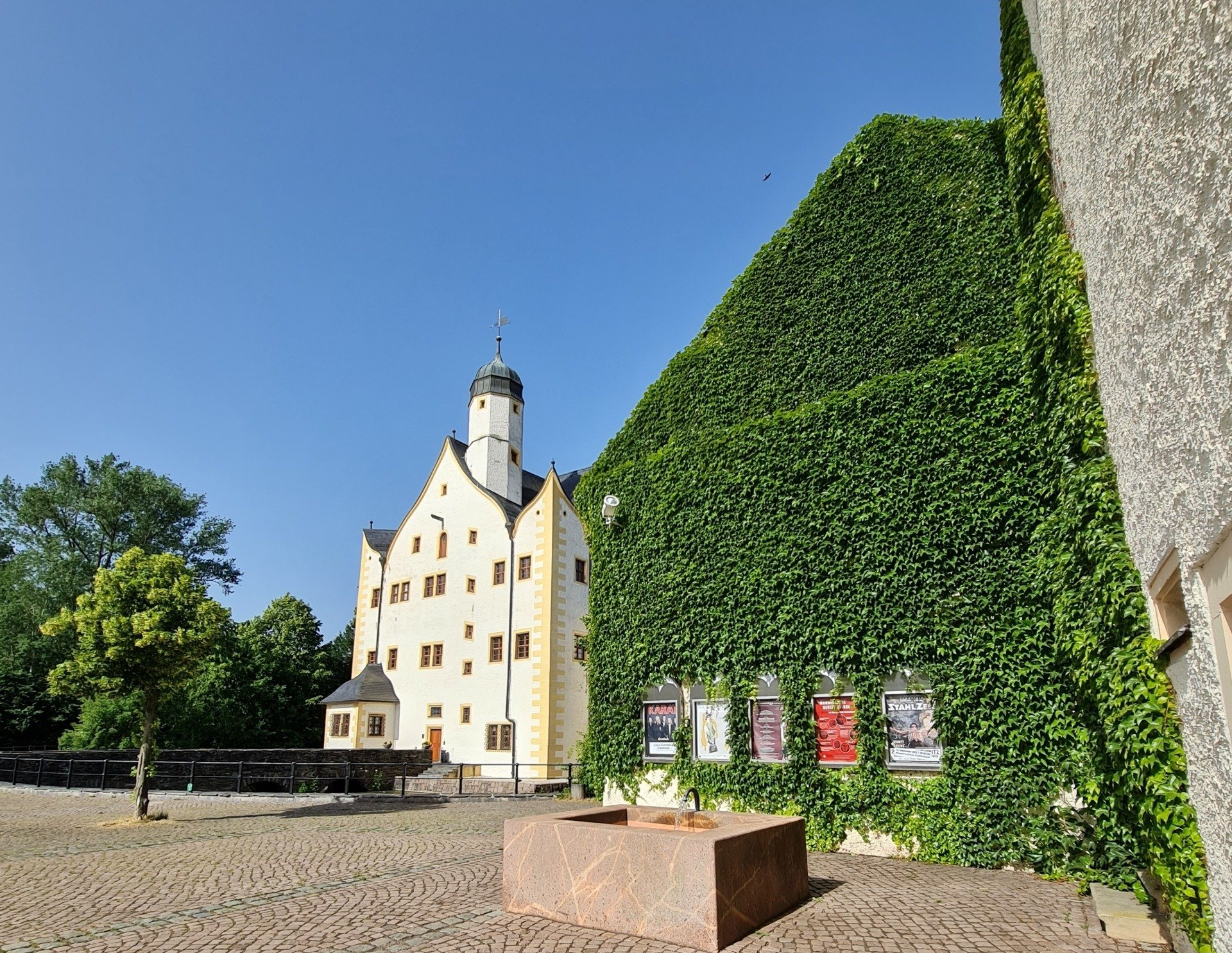 ein Blick auf das Wasserschloss vom Hof aus mit Brunnen und Nebengebäuden