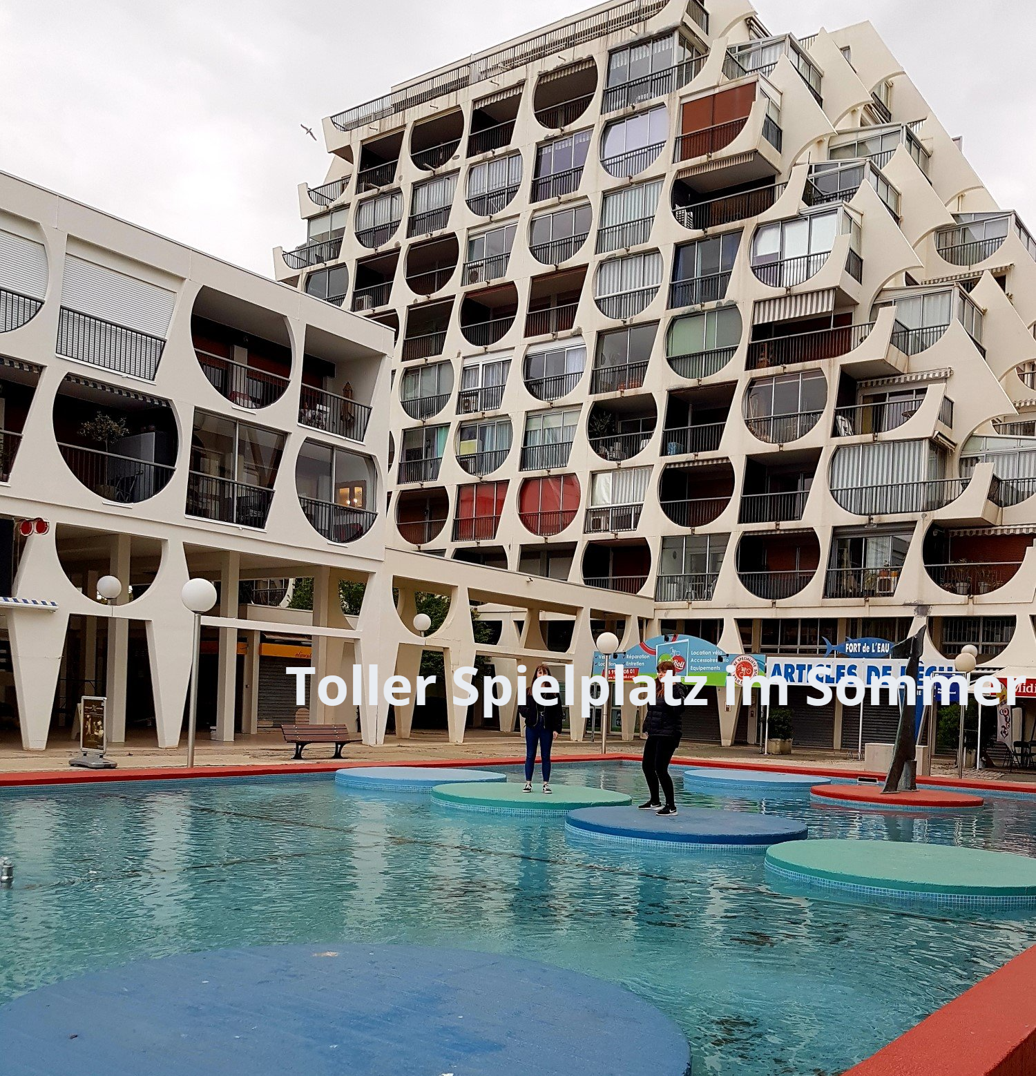 Großes weißes Haus, stufig gebaut, mit vielen kleinen Balkons,