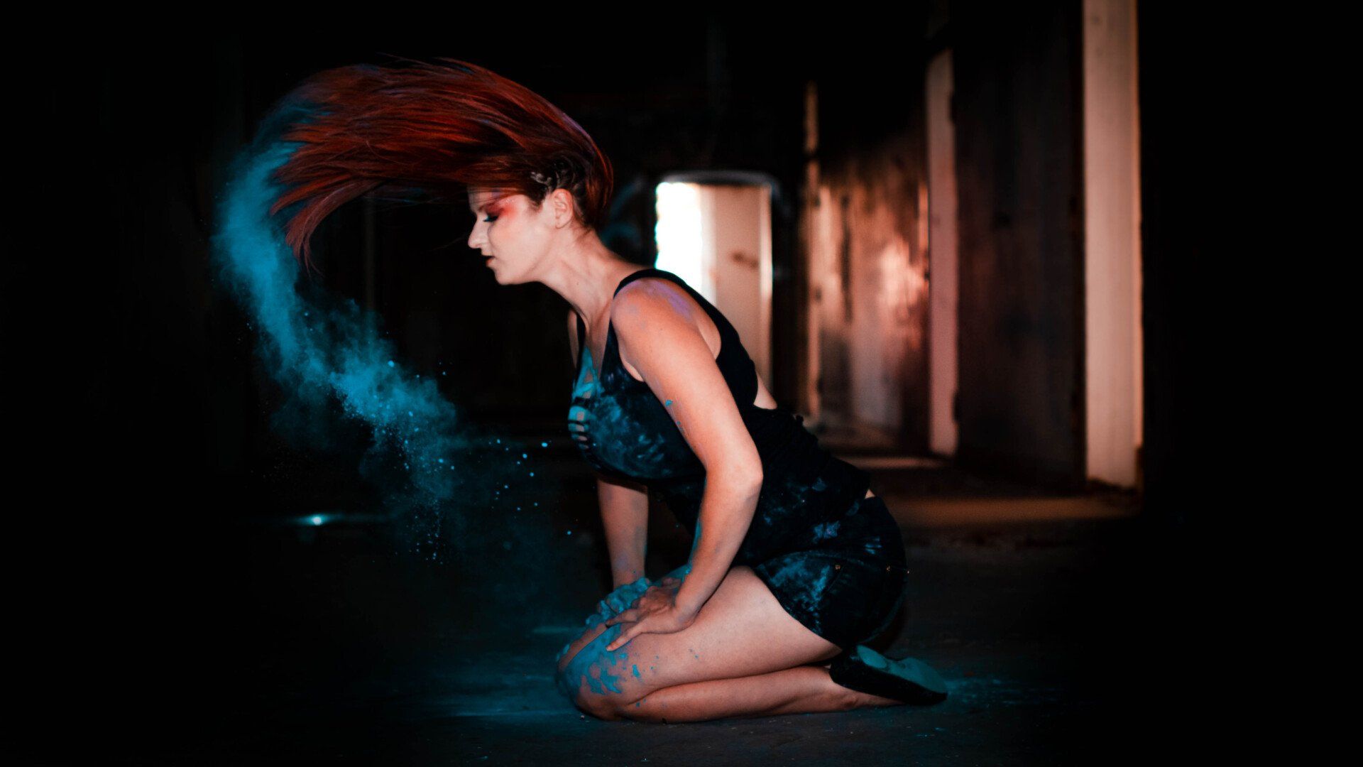 Kreatives Rauchportrait einer Frau in kniender Pose mit dynamischer Bewegung und dunkler Atmosphäre