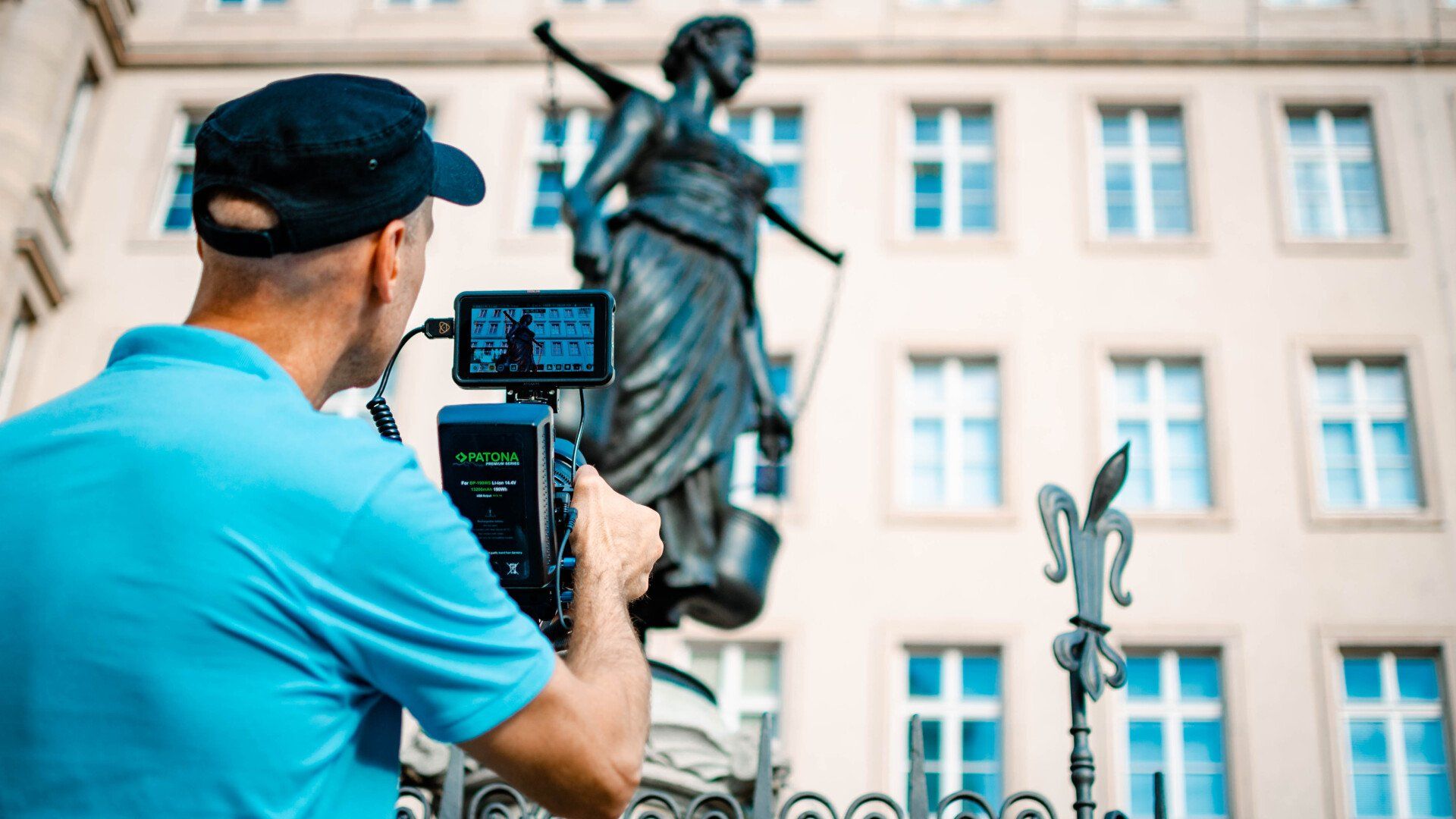 Mann mit Kamera filmt Justitia-Statue in Leipzig – Business- und Reportagefotografie mit Symbolkraft