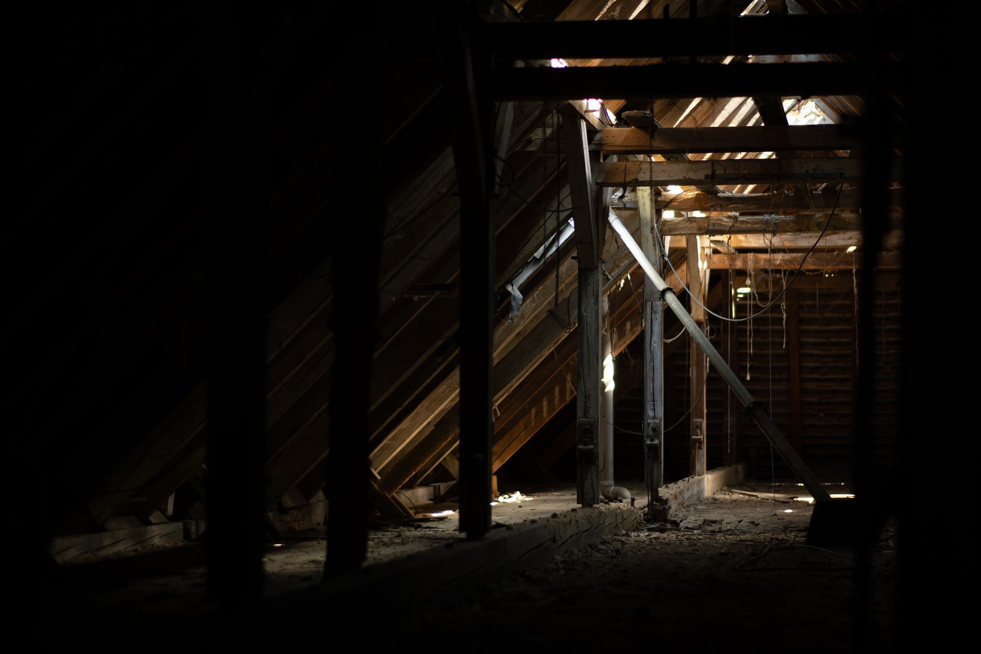 Verlassener Dachboden mit Holzstruktur und einfallendem Licht – atmosphärische Lost-Place-Aufnahme mit sichtbarer Bausubstanz