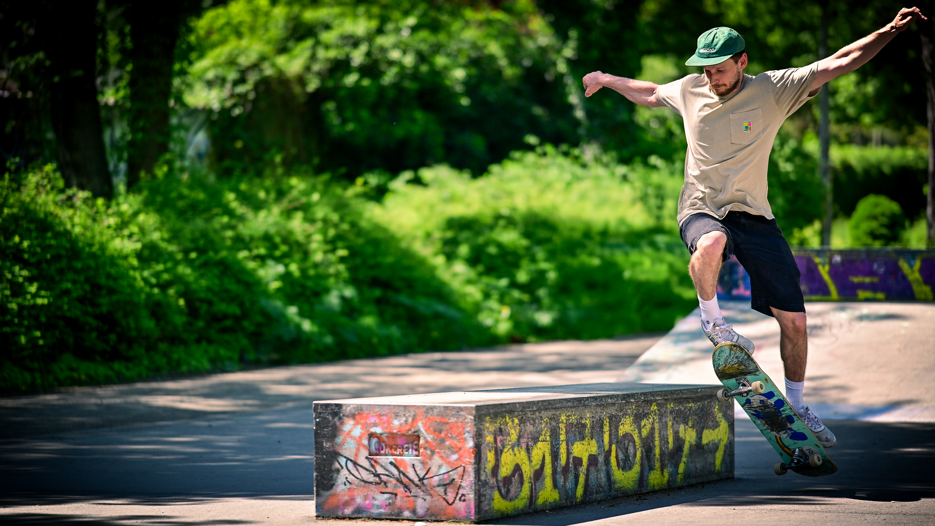 Dynamische Fotografie eines Skateboarders bei einem Trick im urbanen Park