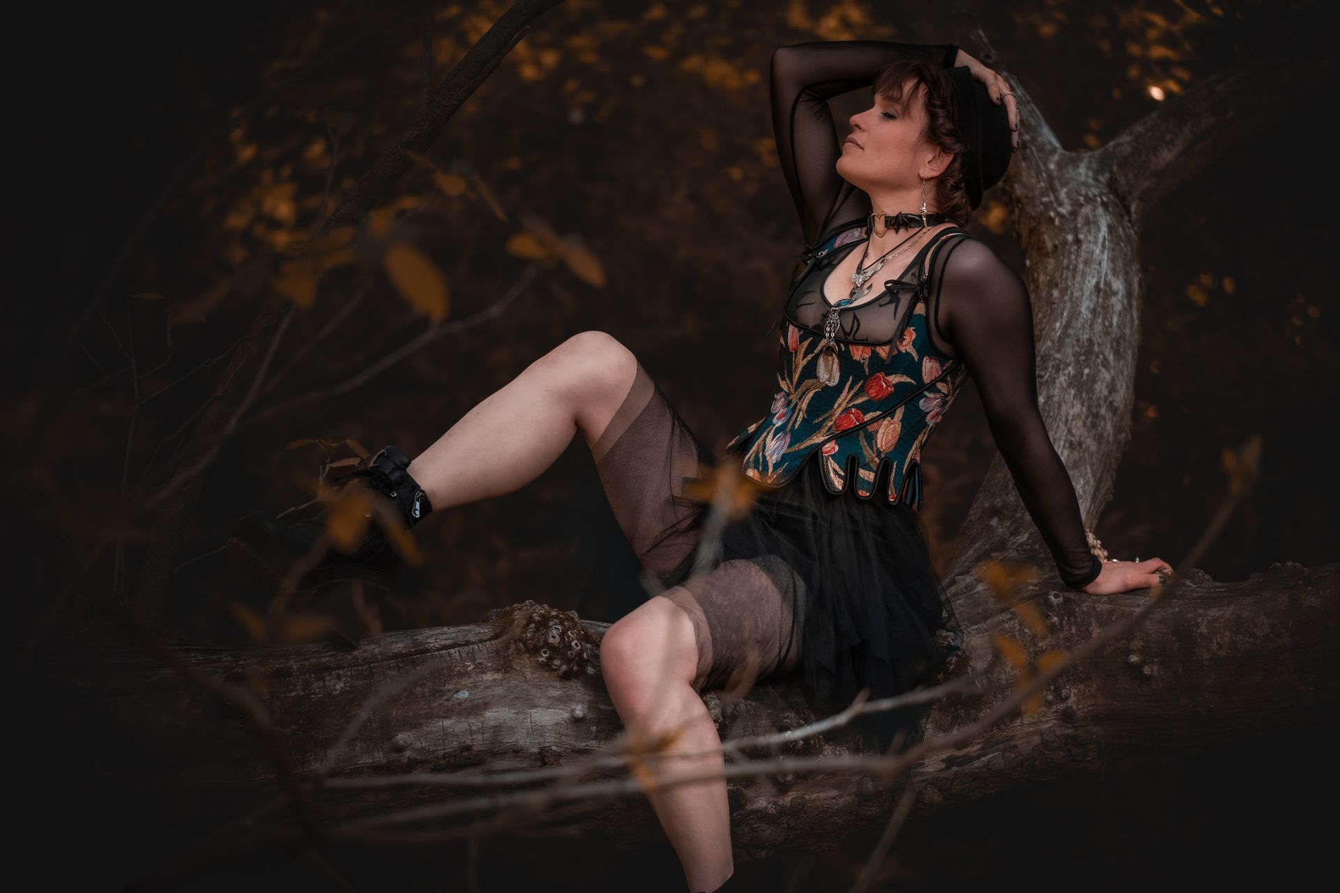 Natürliches Portrait einer Frau im Botanischen Garten Leipzig, sitzend auf einem Baumstamm im warmen Licht