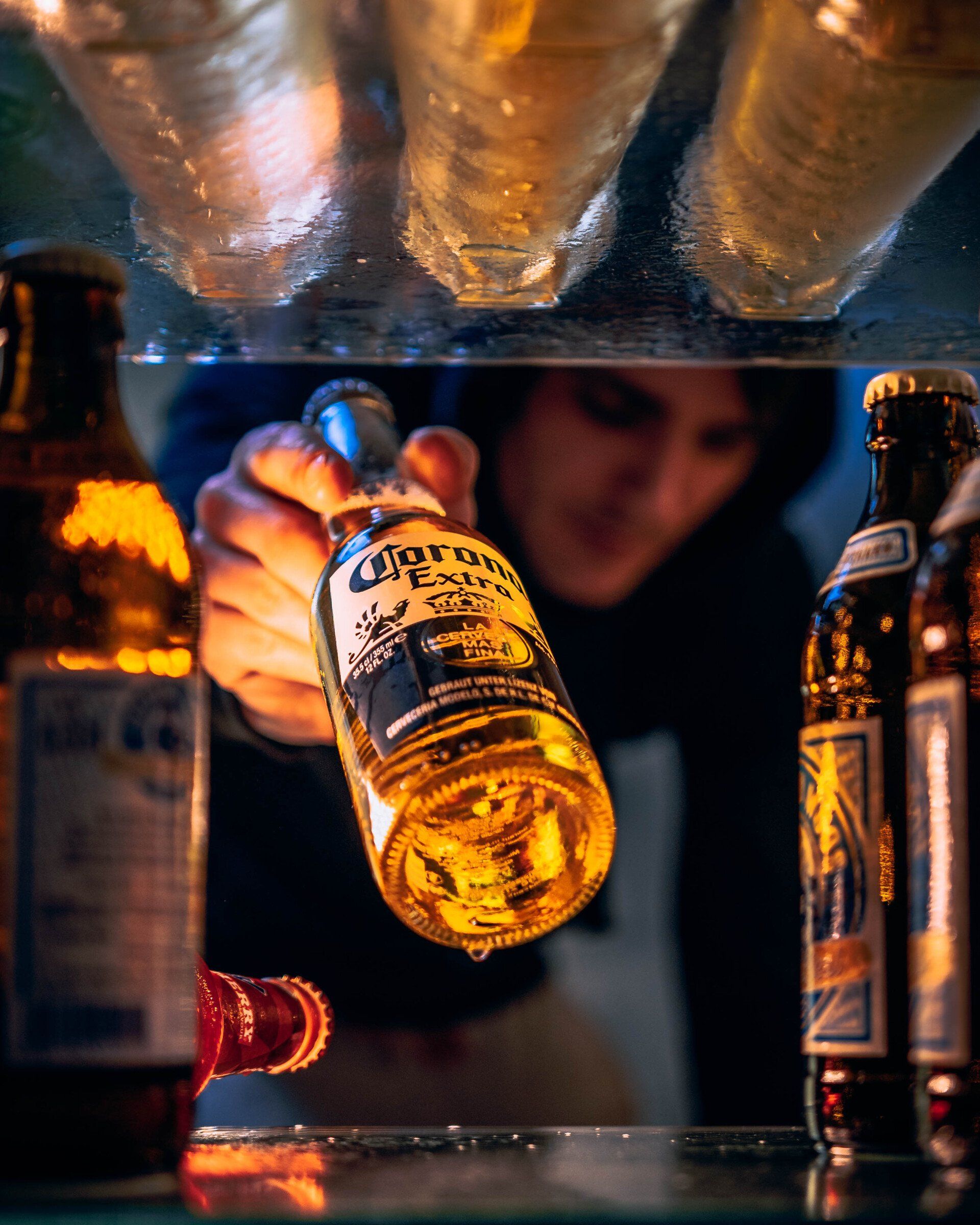Hand greift nach Corona-Flasche im Kühlschrank – kreative Produkt- & Werbefotografie mit Lichtstimmung in Leipzig