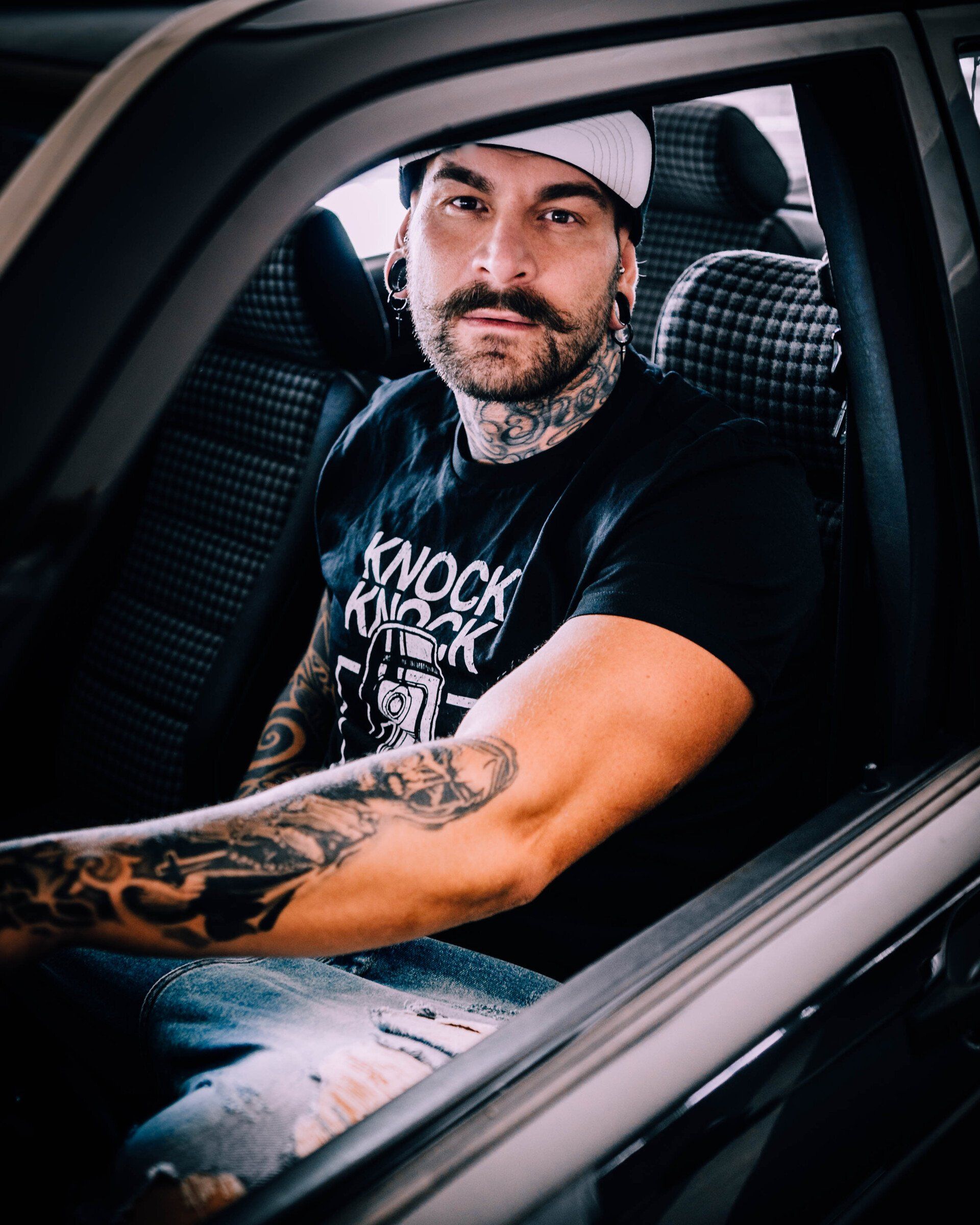 Natürliches Portrait eines Mannes sitzend im Auto mit direktem Blick in die Kamera