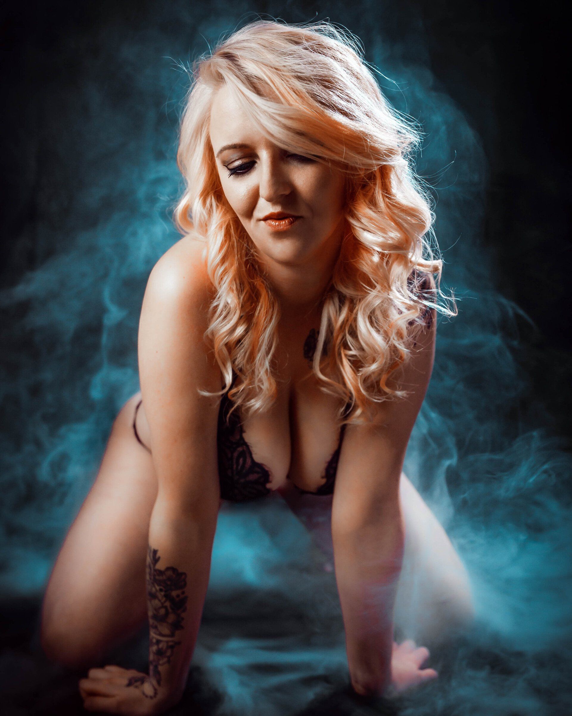 Atmosphärisches Portrait einer Frau mit geschlossenen Augen im blauen Rauch