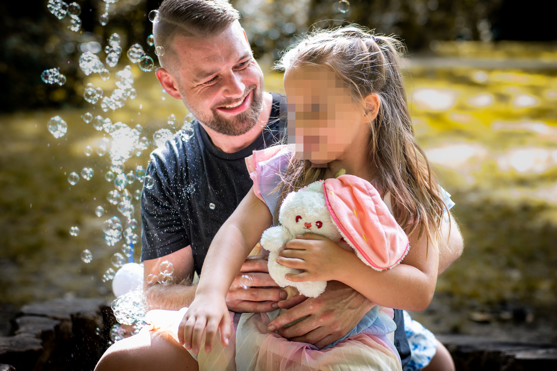 Natürliches Familienshooting mit Vater und Kind im Park bei spielerischem Moment in Leipzig