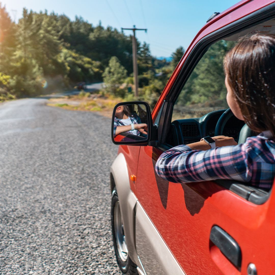 tour self drive donna che guida un auto rossa in strada sterrata