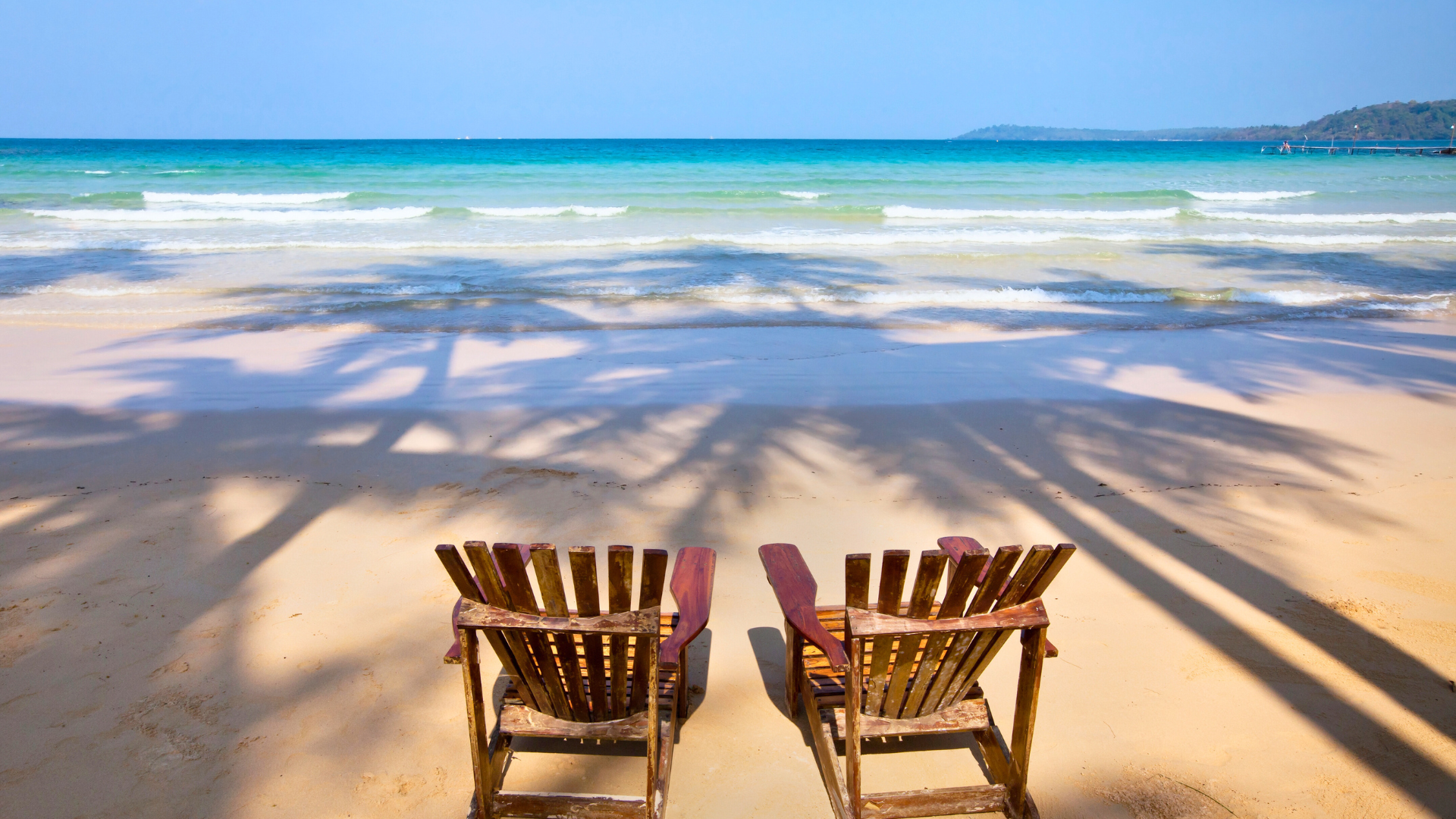 spiaggia deserta con 2 sdraio in legno
