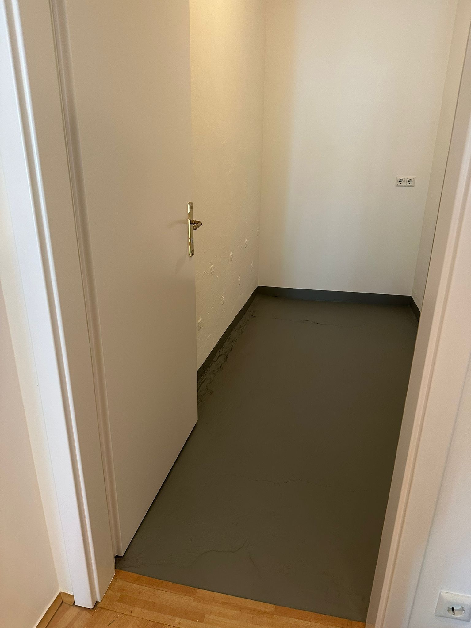 Vorher-Nachher Innenrenovierung Pempelfort: Grauer Estrich-Boden im Flur nach Vorbereitungsarbeiten – Malerbetrieb Murturi Düsseldorf