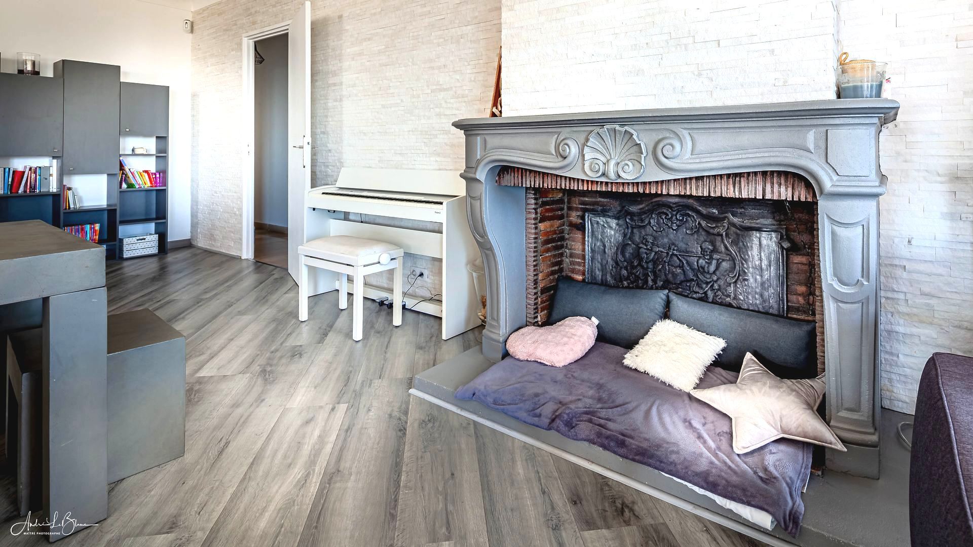 © André LeBlanc, Détail de la salle de séjour avec la cheminée et le piano pour coin cheminée pour Nicolas Pisani & Associés - Beaulieu Centre