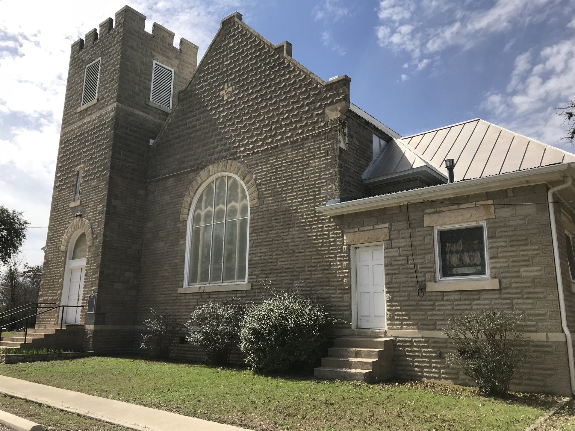 old rock church with high metal roof