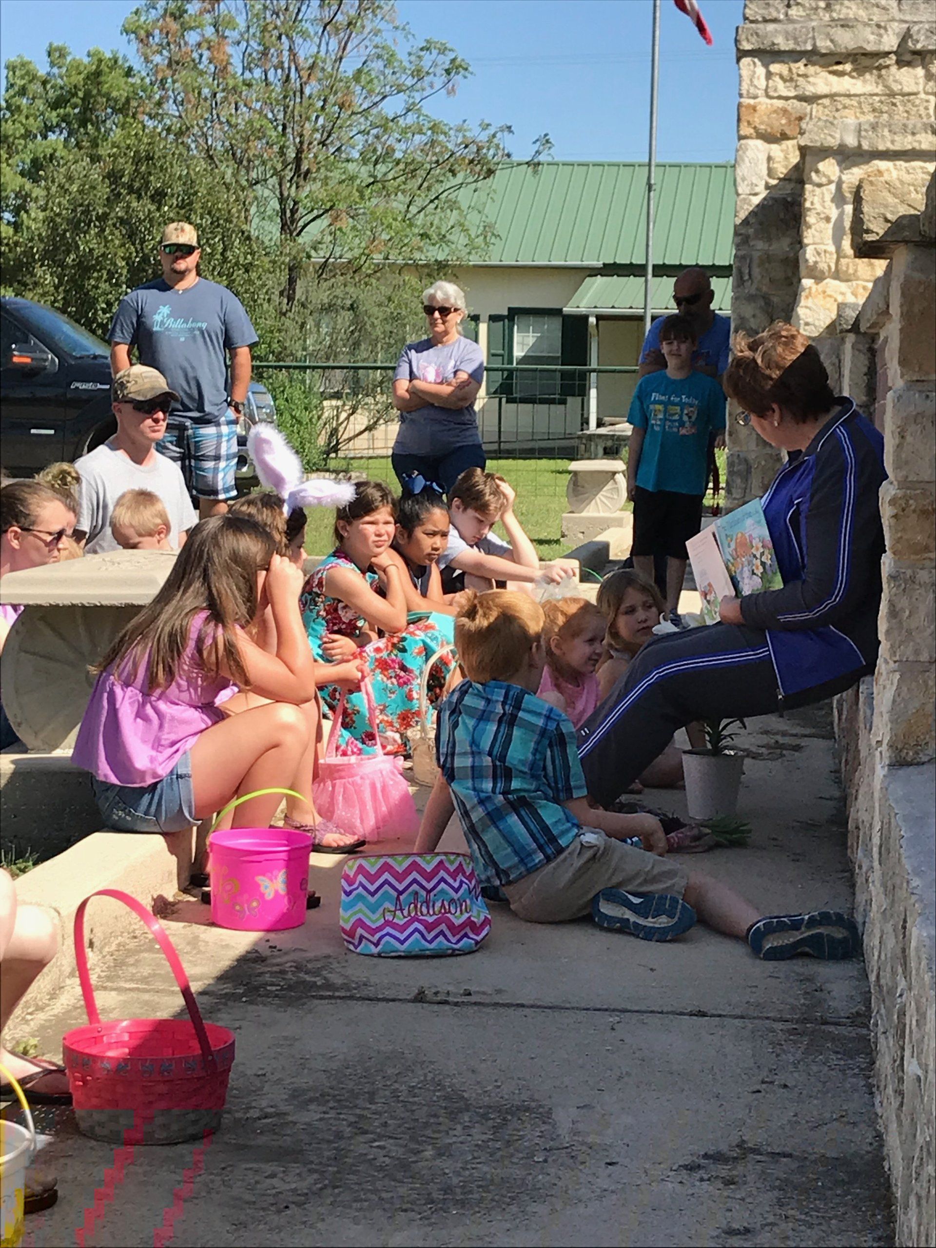 woman sitting with children reading