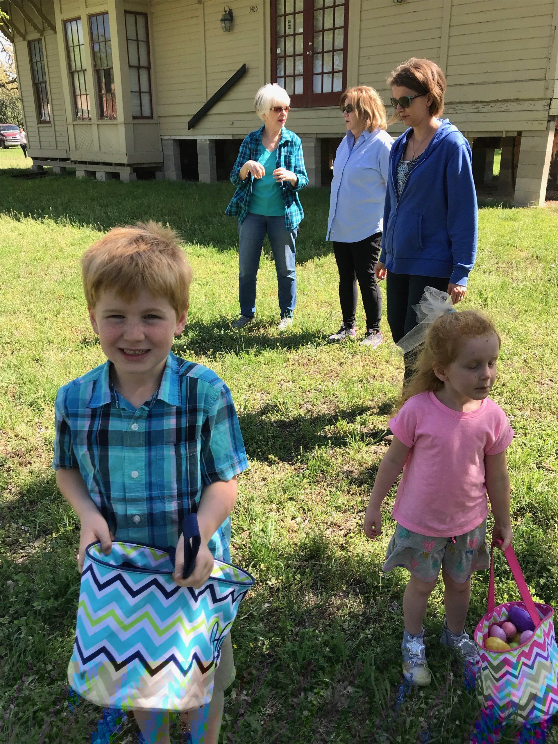 Two young children with bags to collect Easter eggs