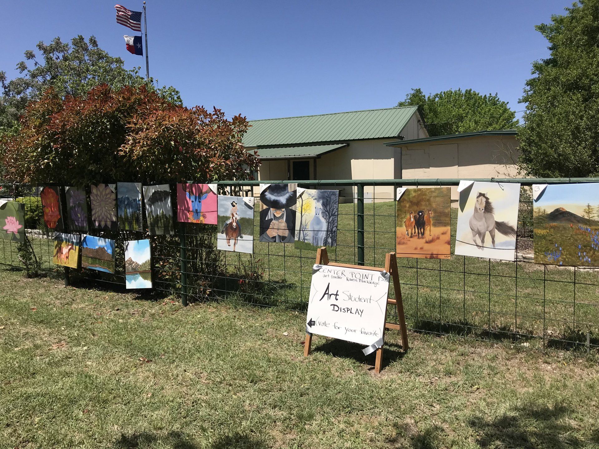 fence with oil paintings hanging on it