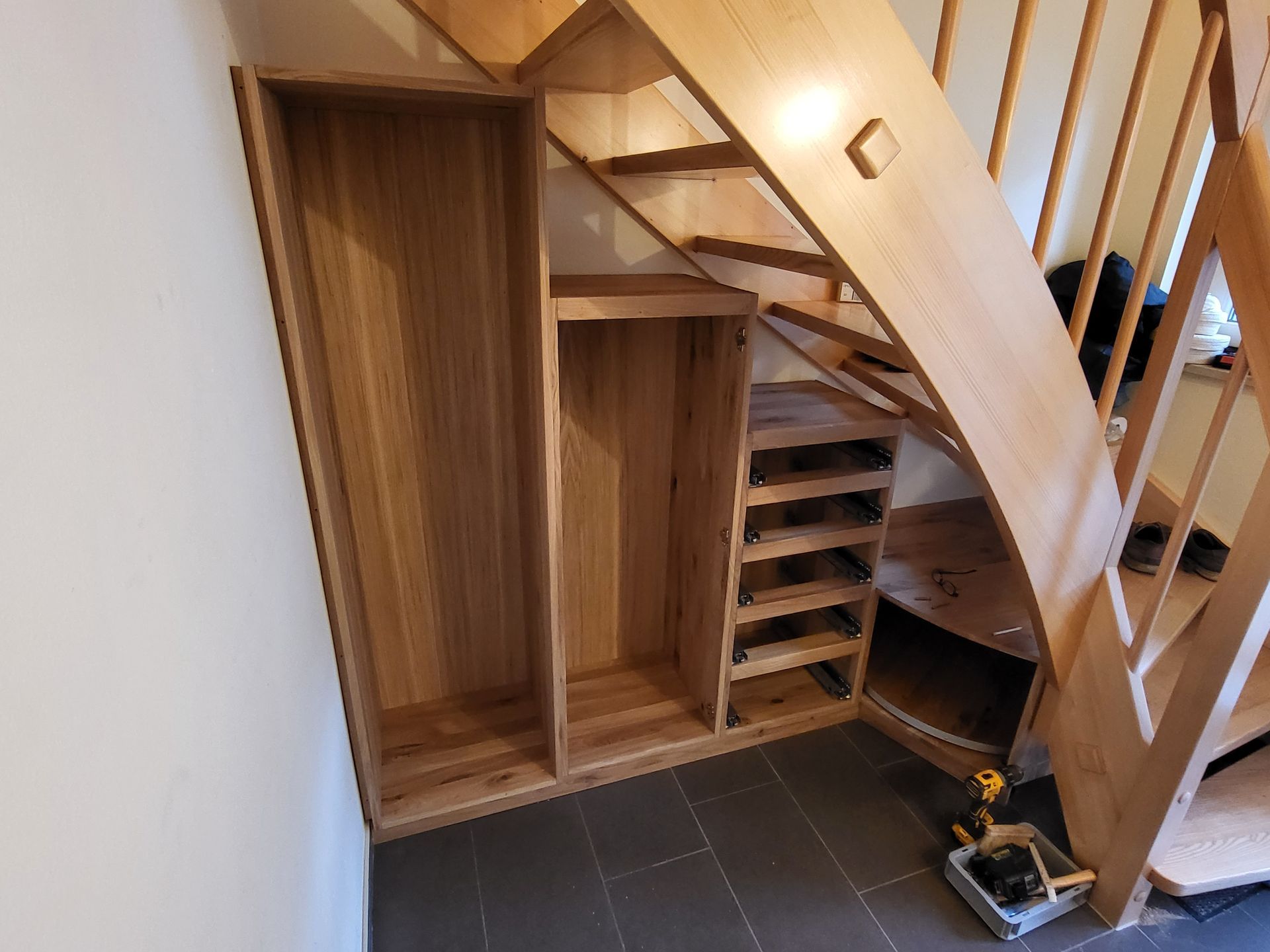 Möbelteile unter Treppe eingepasst mit Eckrondell