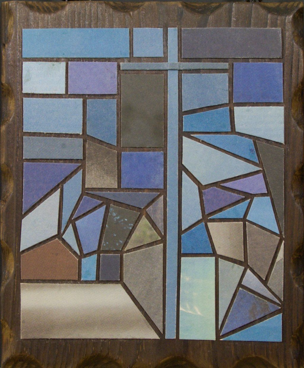 Kleine Kreuzcollage mit blauem Kreuz in unruhiger blauer Papierlandschaft.