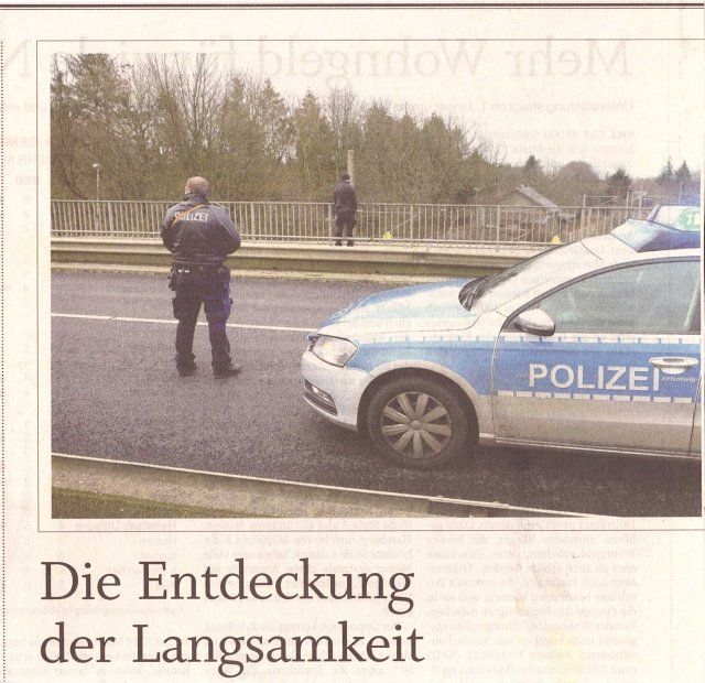 Ein Polizist steht neben einem Streifenwagen auf einer Brücke; darunter die Schlagzeile „Die Entdeckung der Langsamkeit“.