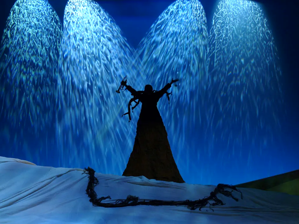 Silhouette einer Theaterfigur vor blauem Sternenregen.