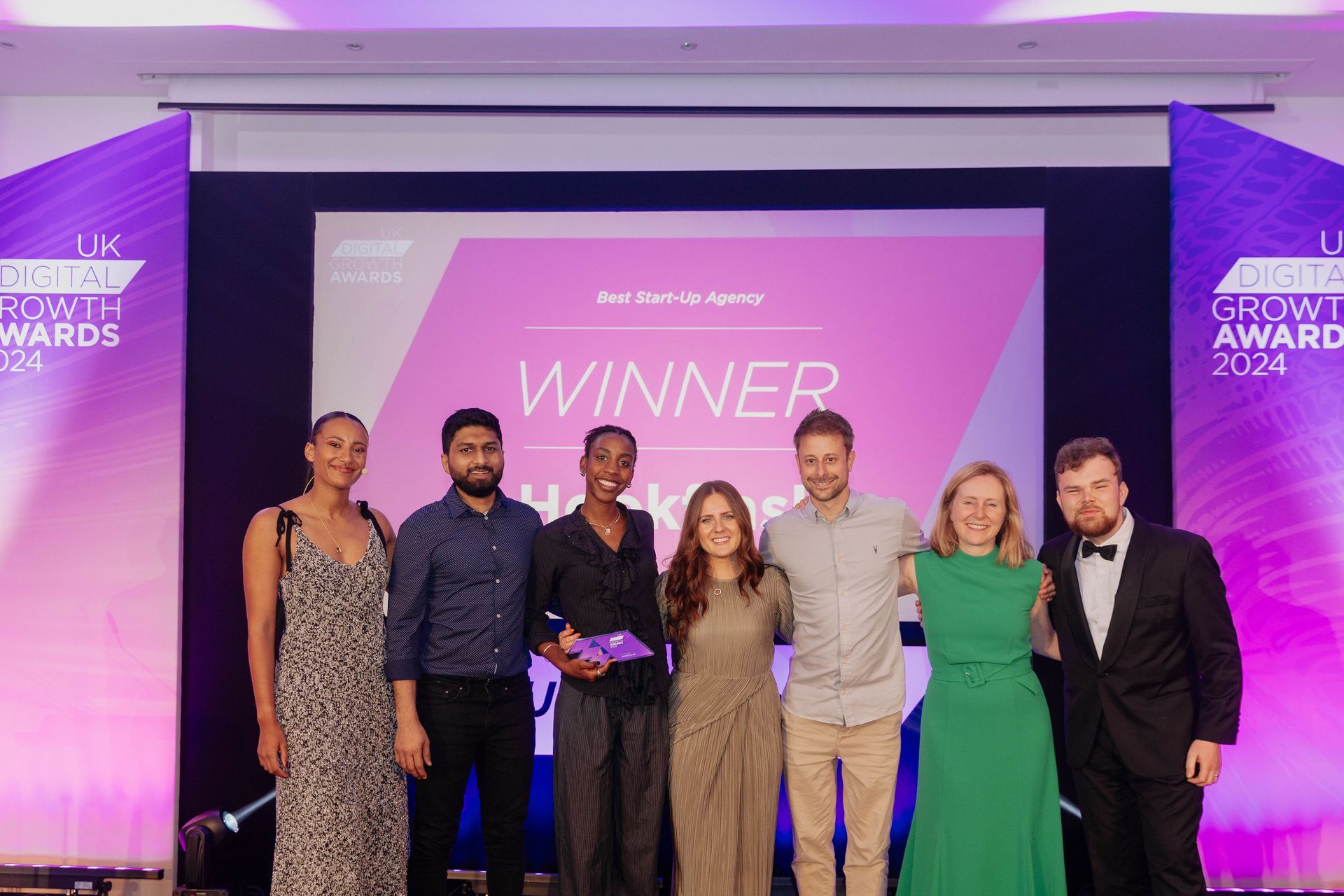 group of people on stage collecting their trophy