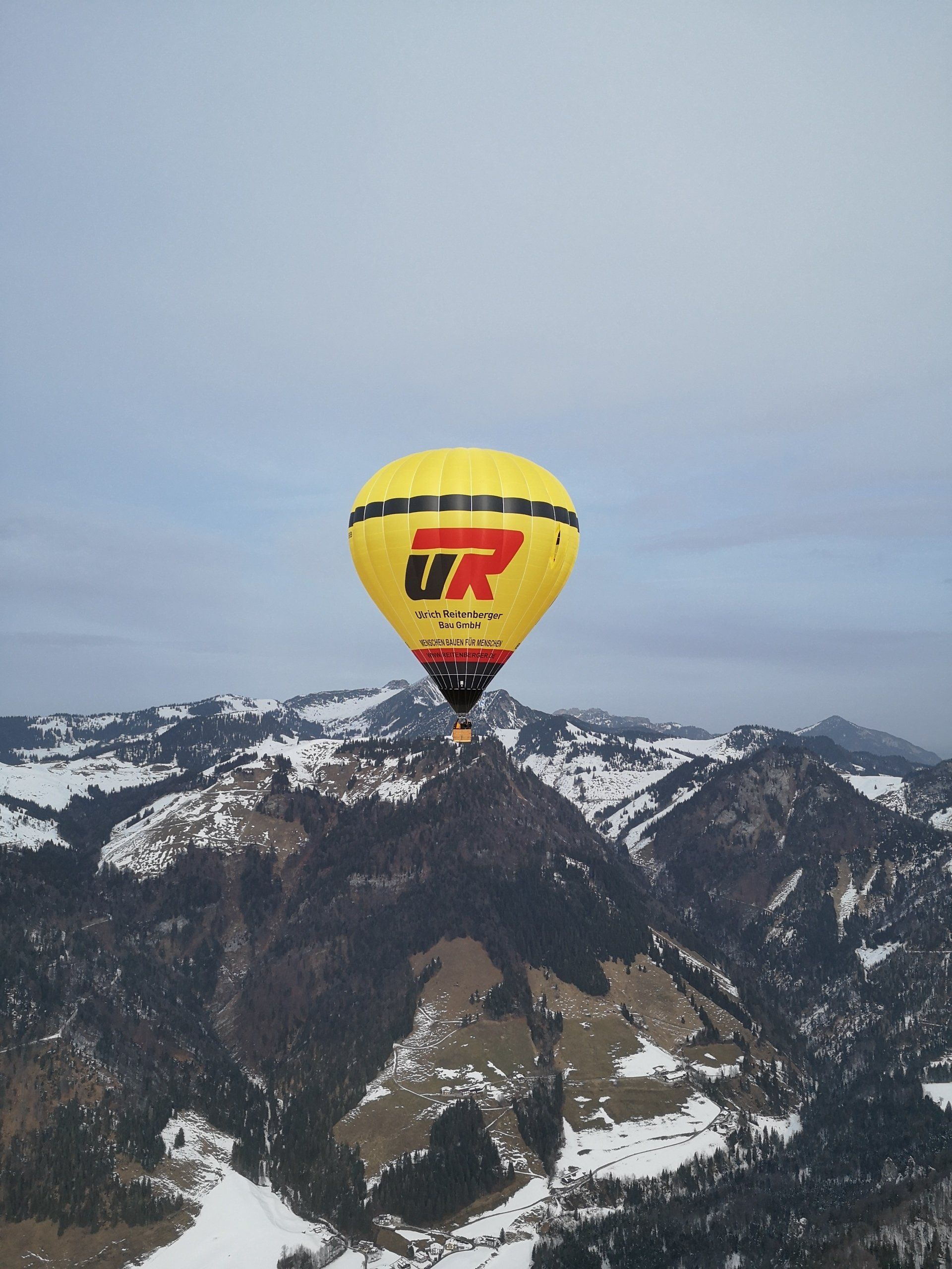 UR Ballon hoch über den winterlichen Bergen