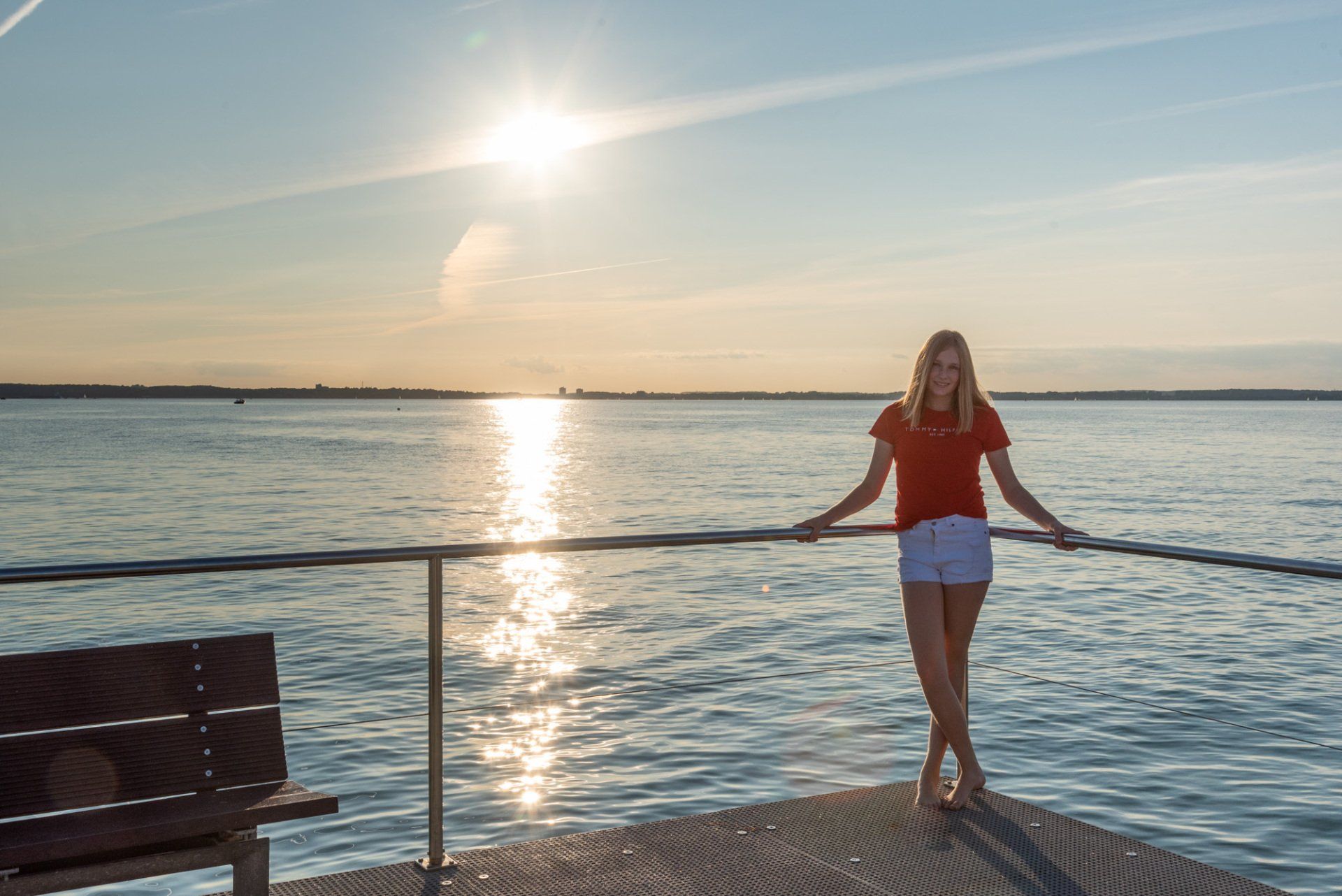 Mädchen in Stein auf der Seebrücke im Sonnenuntergang