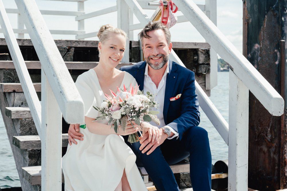 Kiellinie, Brautpaar sitzt auf Steg und lacht