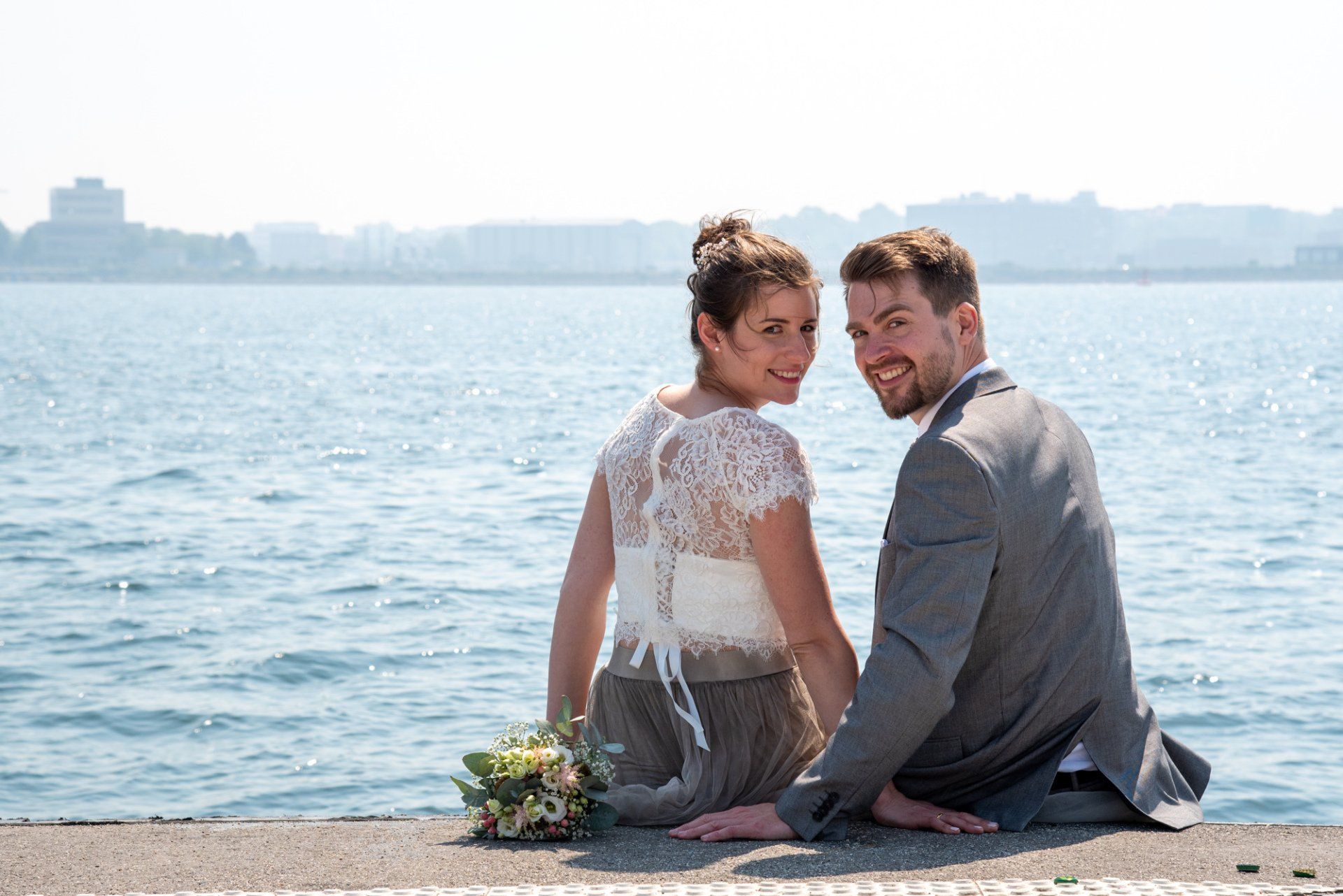 Fotograf Kiel Brautpaar sitzt auf Steg und schaut sich um