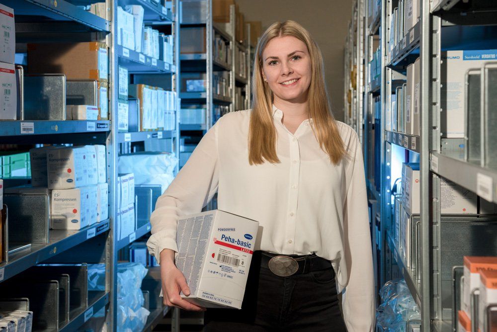 Mitarbeiterin zwischen den regalen in der Firma Marmed