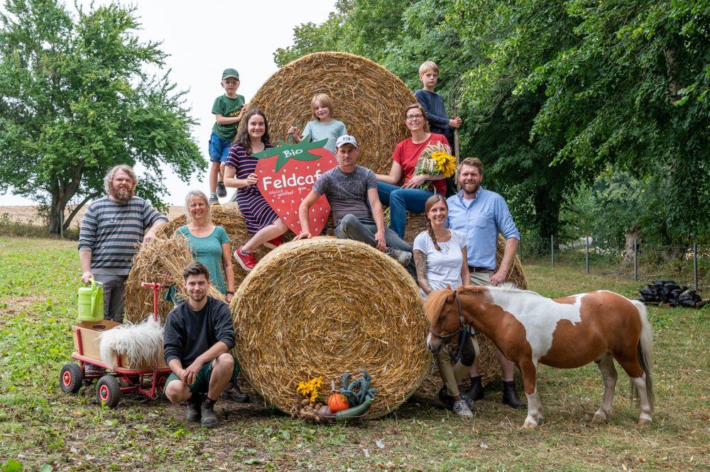 Mitarbeiterteam von Gut Birkenmoor auf Rundballen sitzend