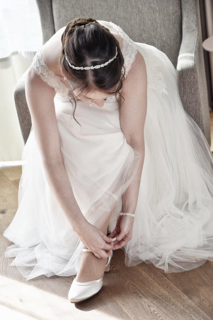 <img src=”Hochzeitsfotograf-Kiel-Braut-beim-getting-ready.jpg” alt=”Braut macht sich beim getting ready die Schuihe zu”>