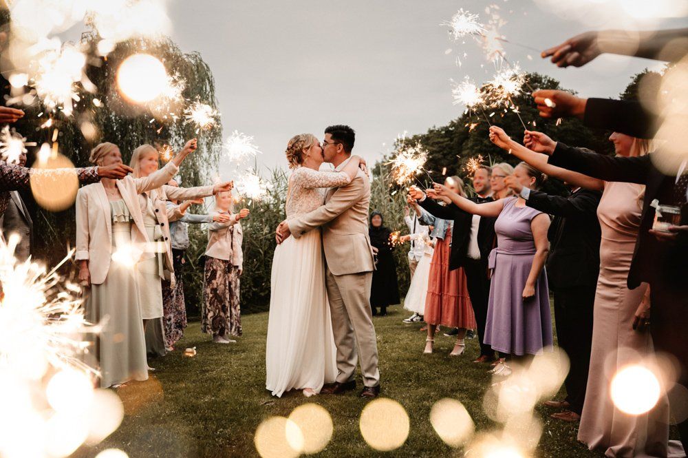 Brautpaar küssend im Wunderkerzen Spalier