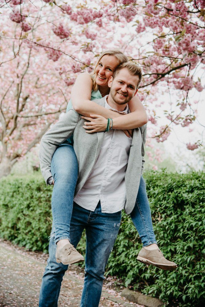 Mann hat Frau auf Huckepack in Kirschblütenallee Kiel