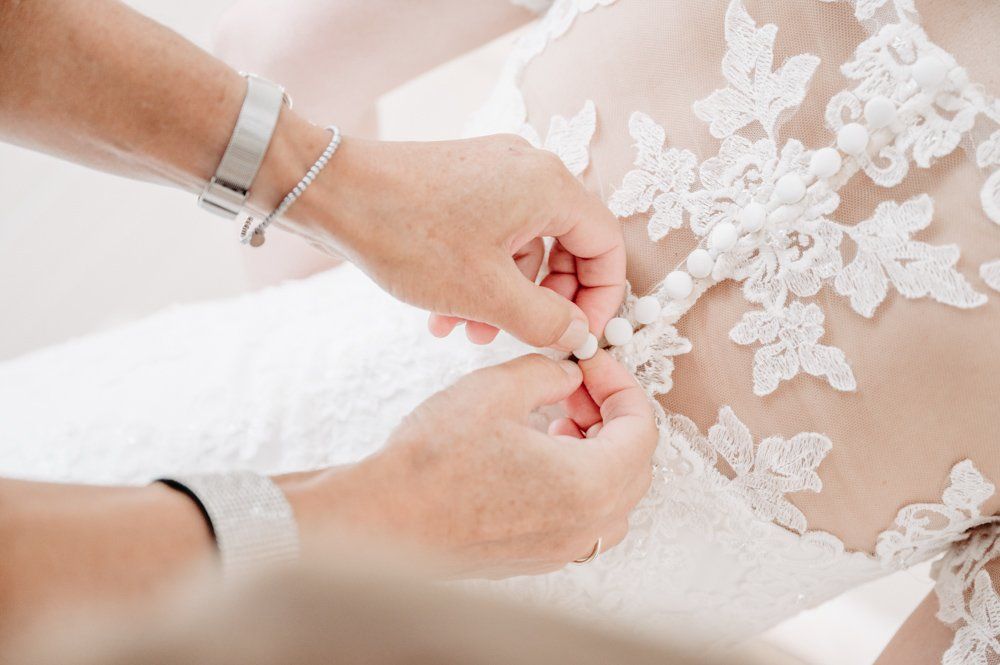 getting ready, Mutter knöpft Brautkleid zu